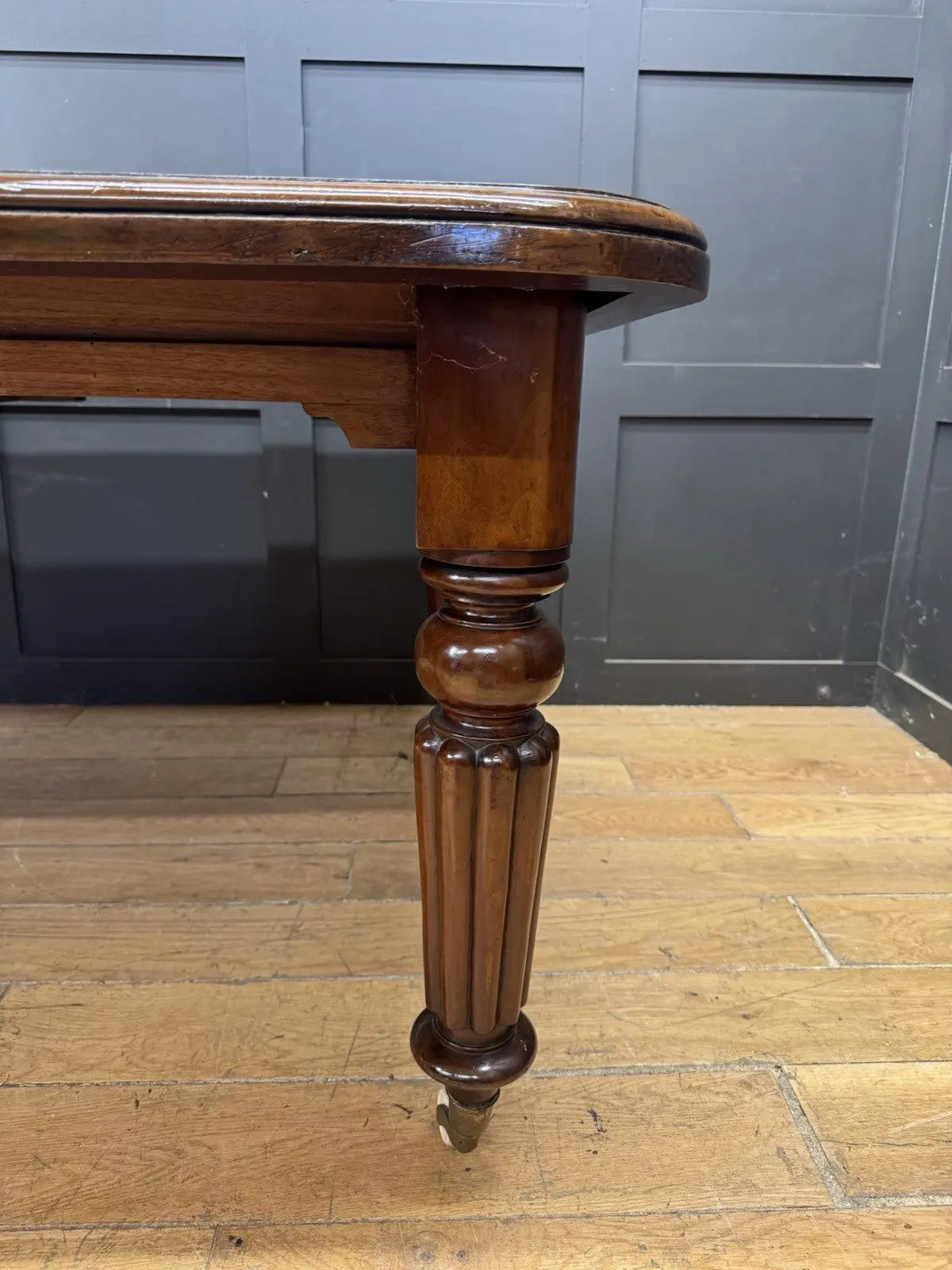 Victorian mahogany dining table brown fluted legs with brass castors and wind-out mechanism.