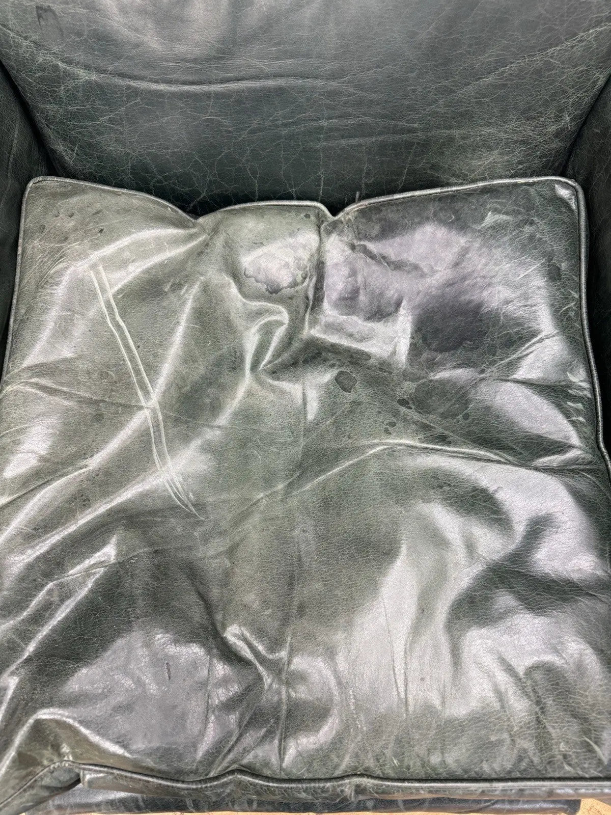 Tetrad green leather armchair with gathered detailing, twisted piping, and original manufacturer's label.