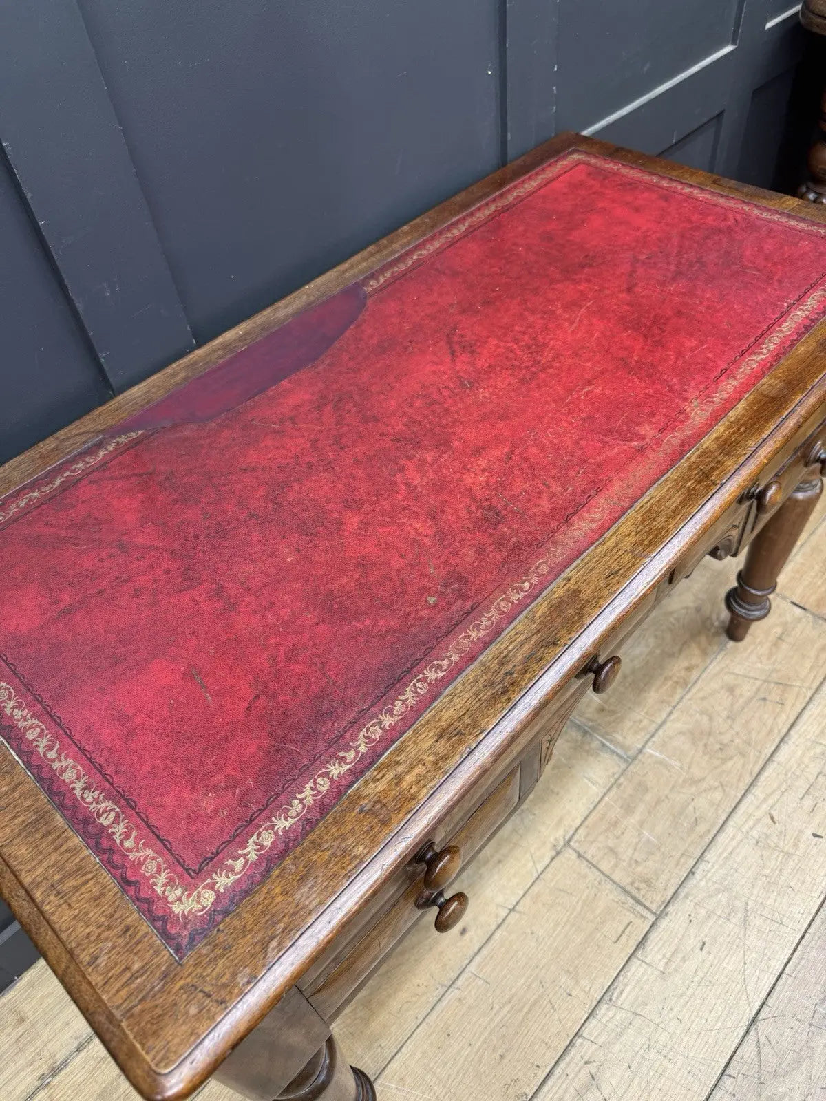 Victorian mahogany writing desk brown with red leather surface and four drawers.