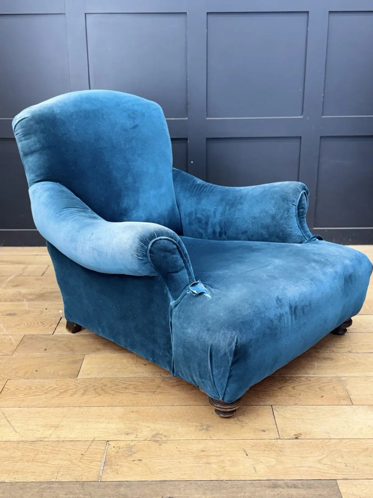 Antique blue velvet armchair with curved back, scroll arms, and stamped 'P' on frame.