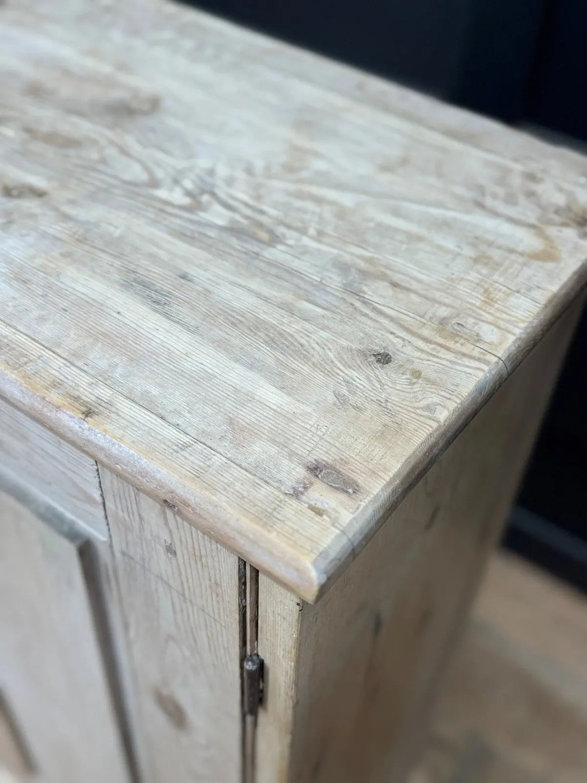Antique beige pine cupboard with stripped finish, brass knob, and painted interior.