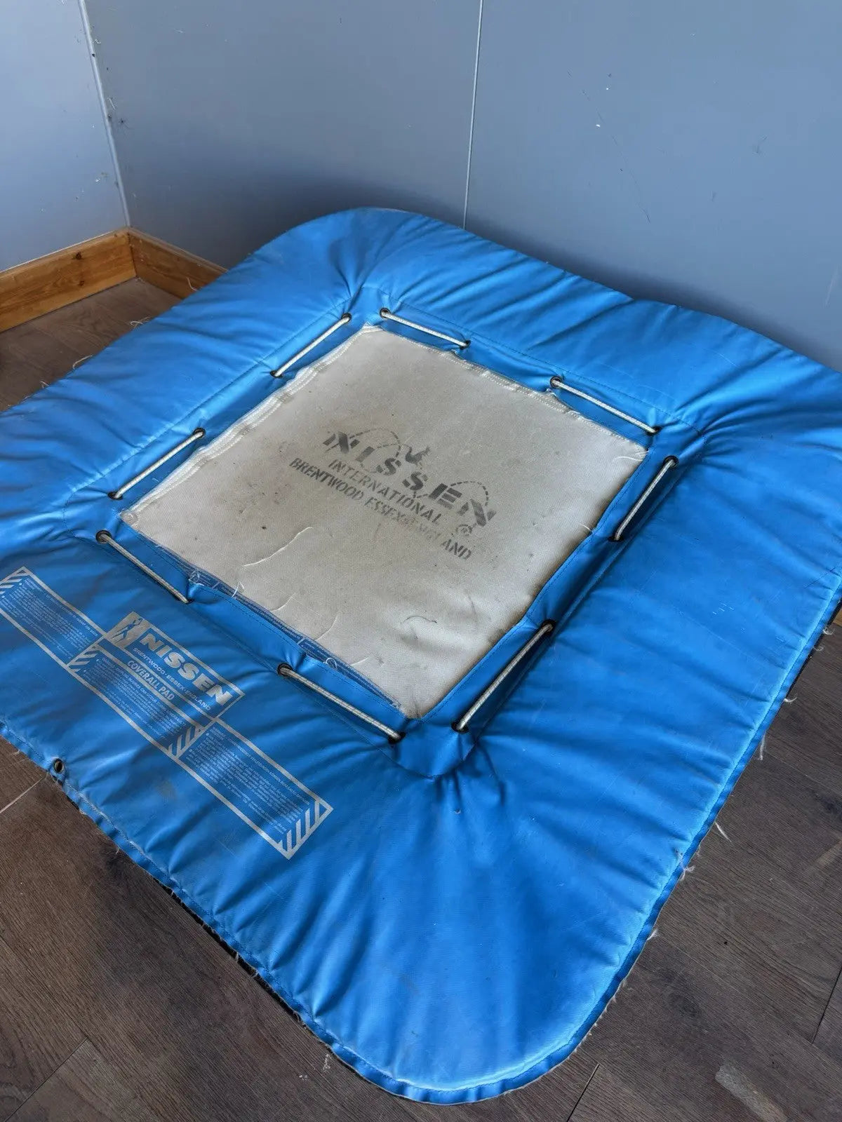 Rebounder black and blue gymnastics trampette with Nissen International logo and woven jumping bed.