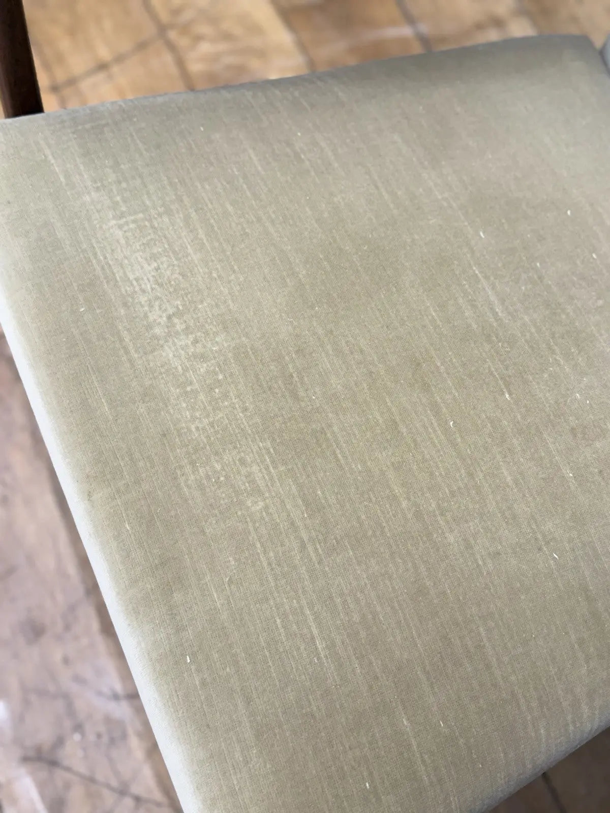 Parker Knoll cream armchairs with sculpted wooden arms and tapered legs, vintage mid-century design.