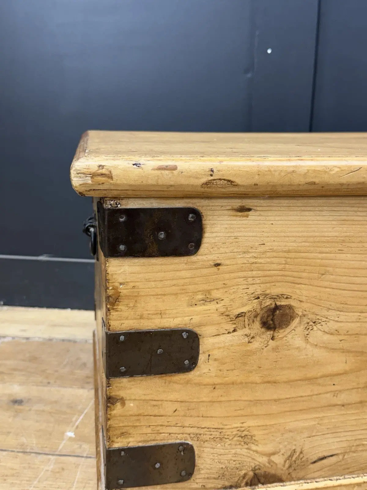 Vintage pine coffee table brown with natural grain and dark metal corner brackets.