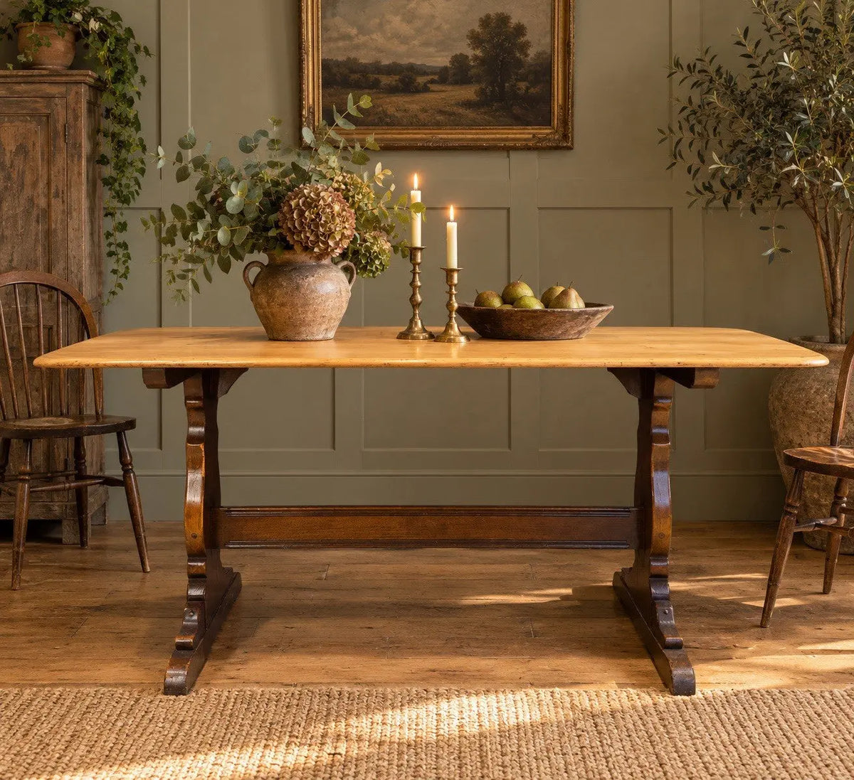 Ercol brown oak refectory dining table with natural wood grain and traditional trestle base.