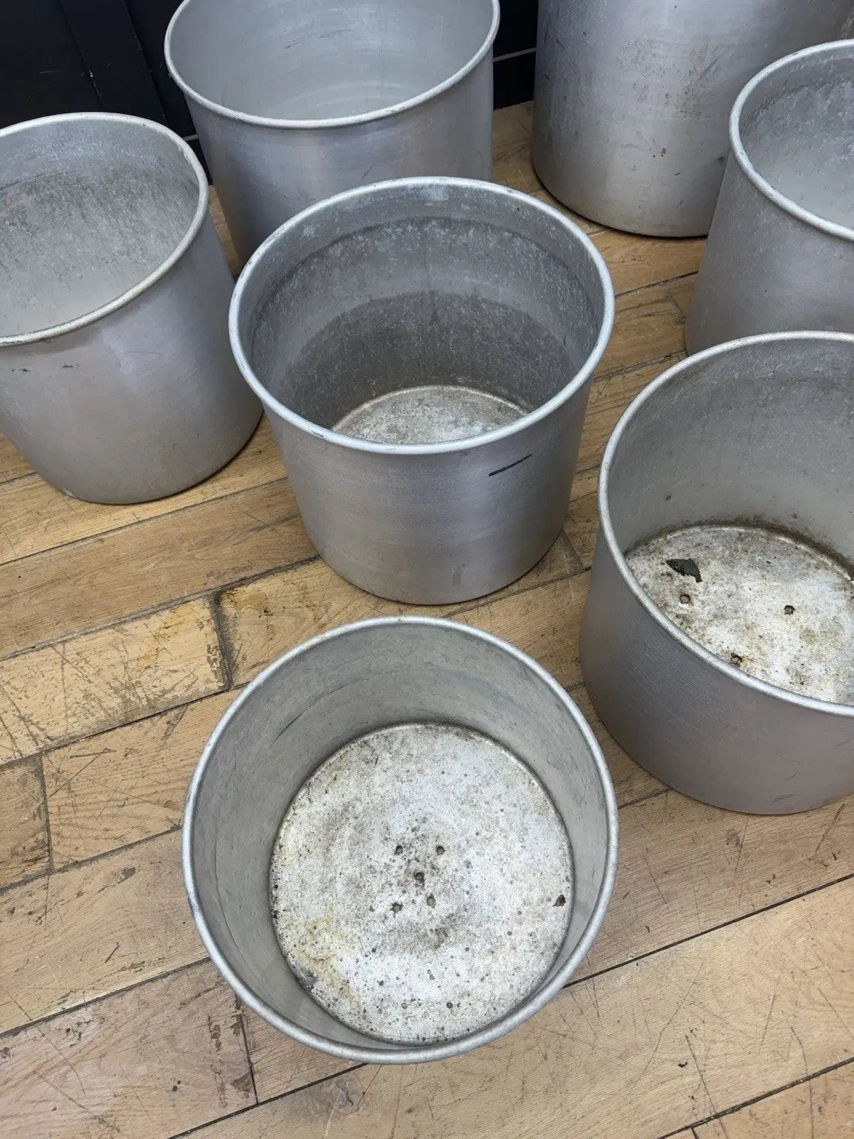 Parisotto green aluminium planters set of seven with cylindrical bodies and maker's label.