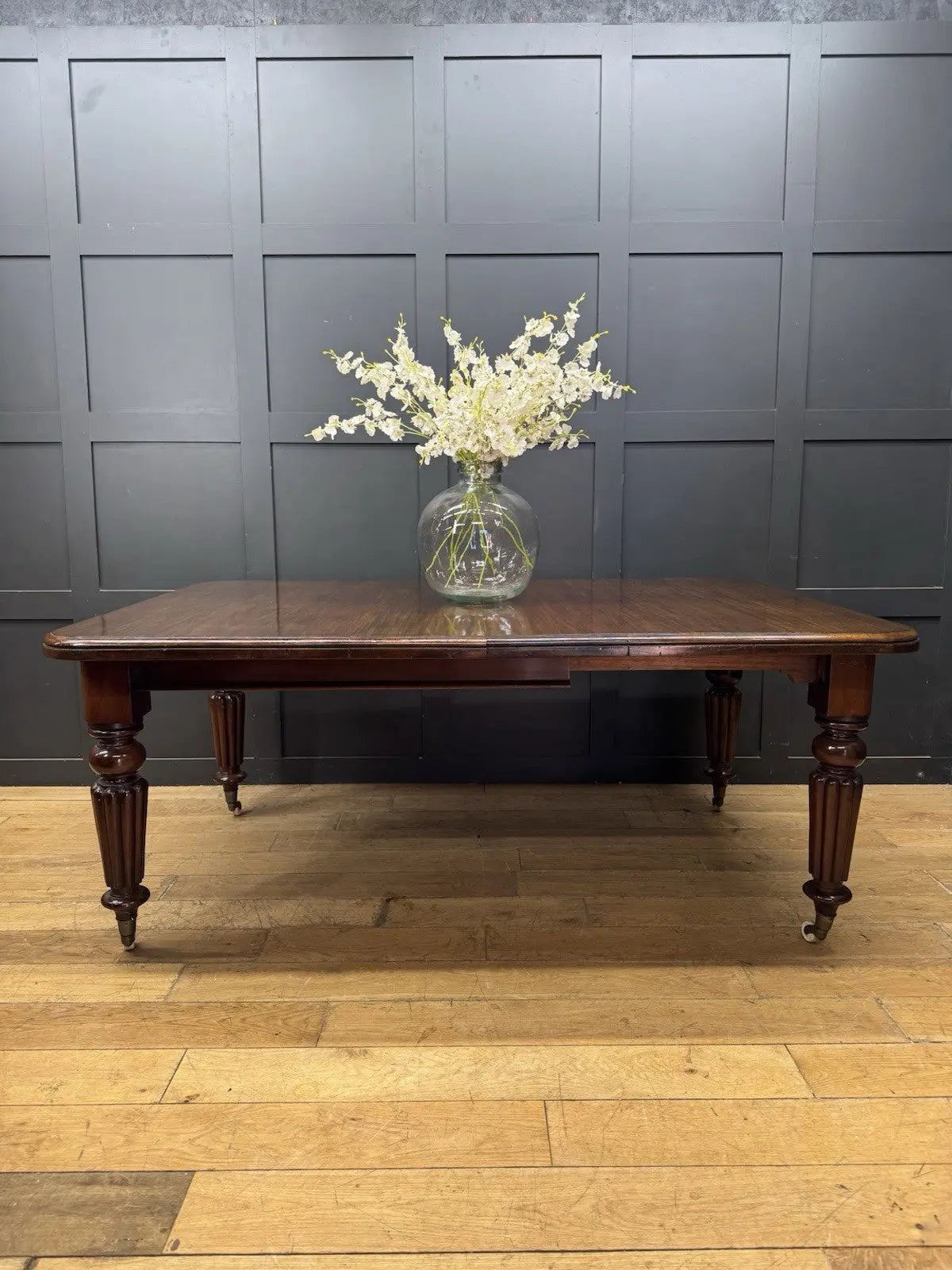 Victorian mahogany dining table brown fluted legs with brass castors and wind-out mechanism.