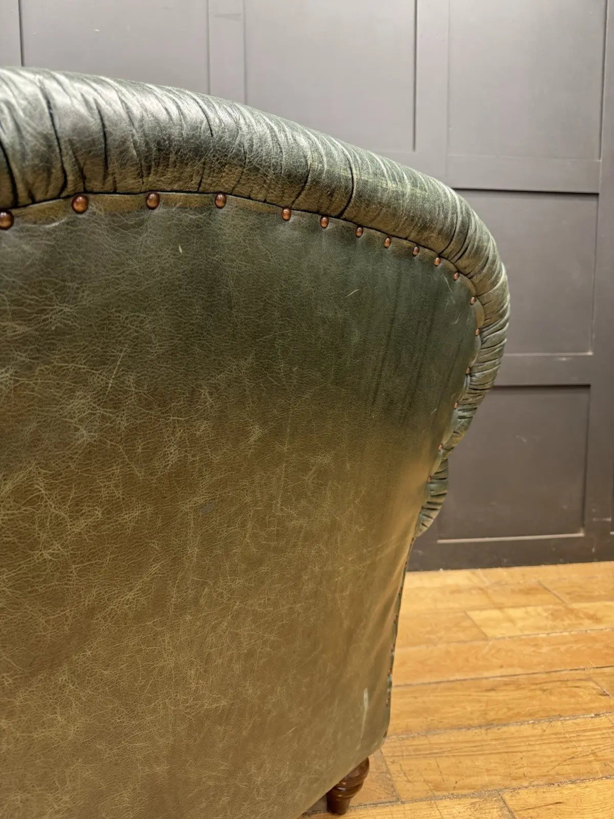 Tetrad green leather armchair with gathered detailing, twisted piping, and original manufacturer's label.