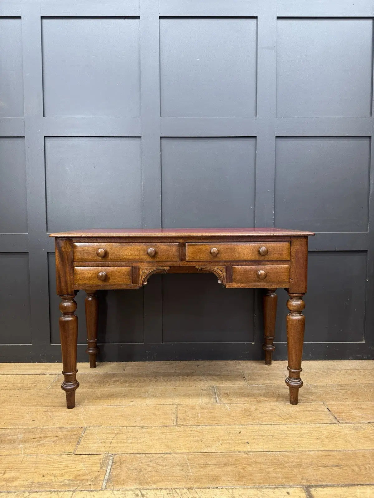 Victorian mahogany writing desk brown with red leather surface and four drawers.
