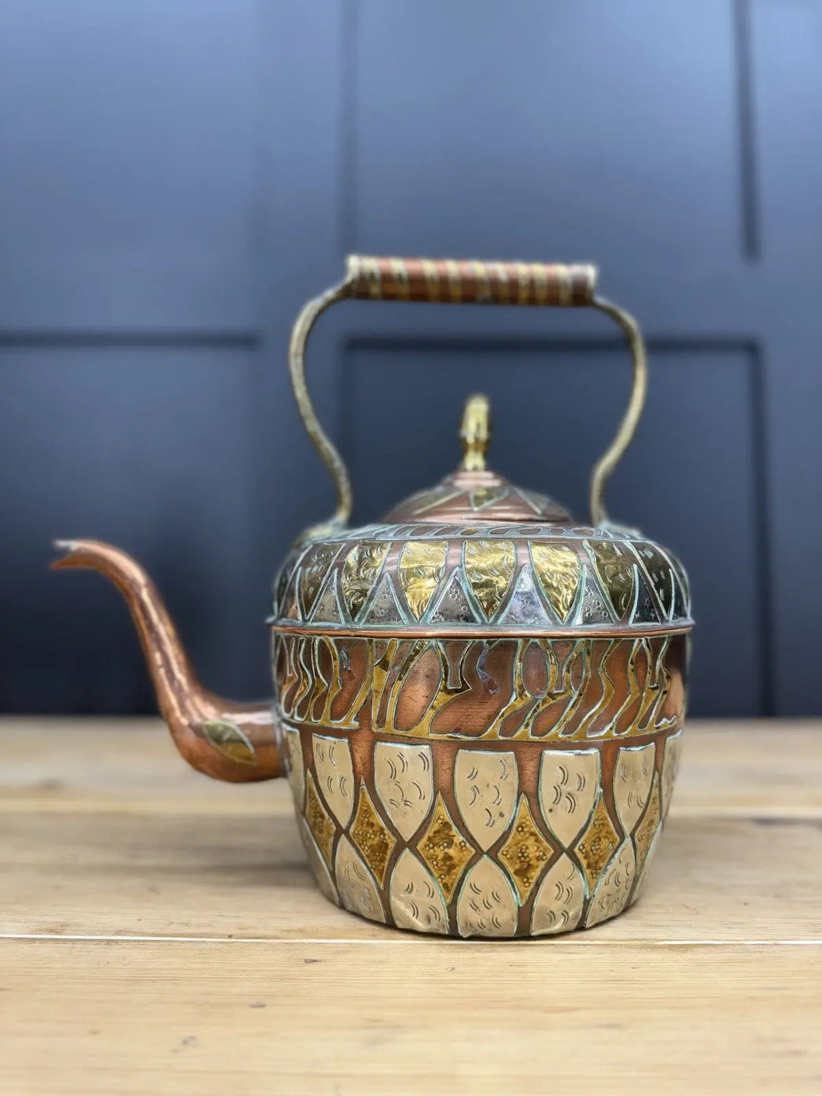 Antique Moroccan copper tea kettle and brass cauldron planter with ornate geometric patterns.