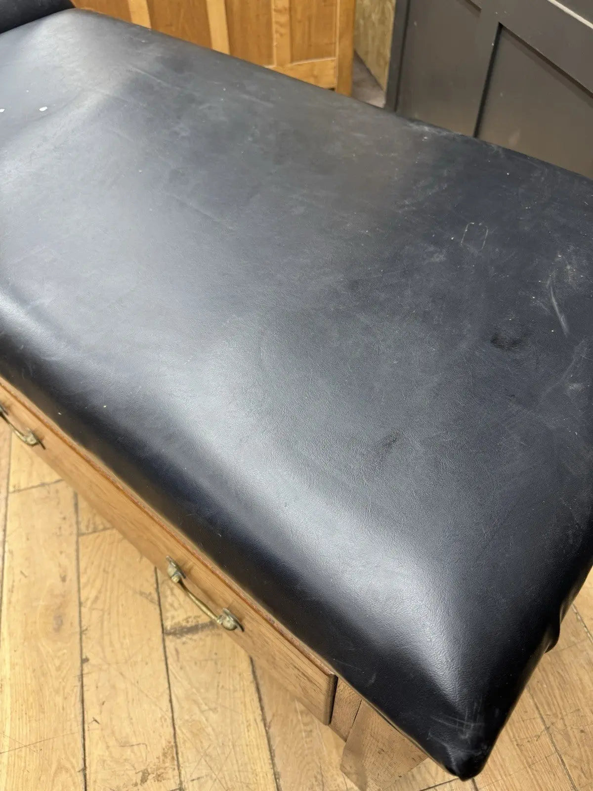 Harris black chaise longue with oak frame, padded Rexine seat, and original maker's plaque.