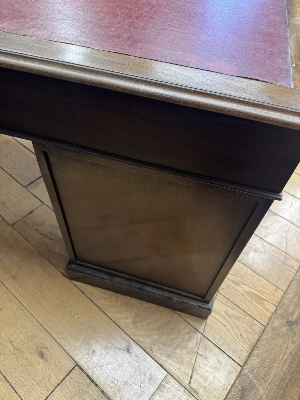 Twin antique mahogany writing desk with red leather top and brass swan-neck handles.