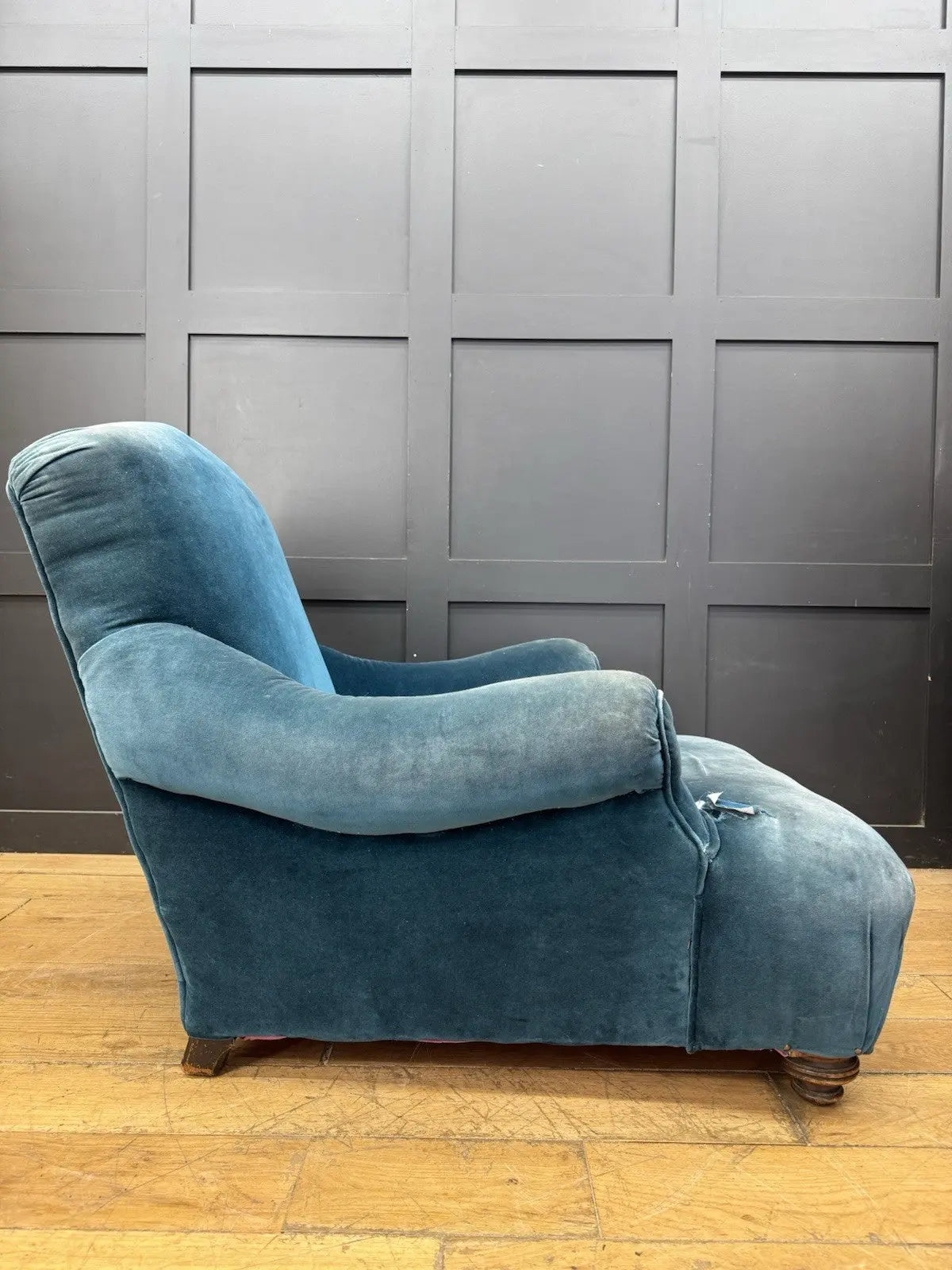 Antique blue velvet armchair with curved back, scroll arms, and stamped 'P' on frame.