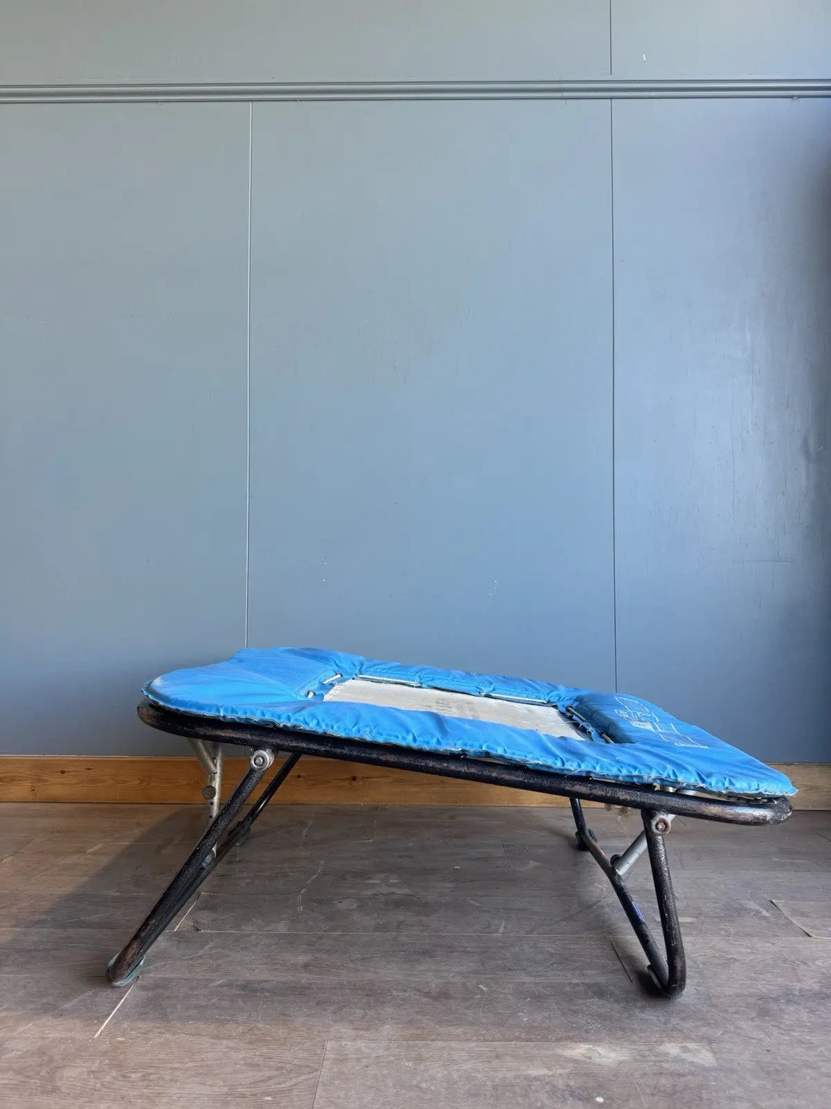 Rebounder black and blue gymnastics trampette with Nissen International logo and woven jumping bed.