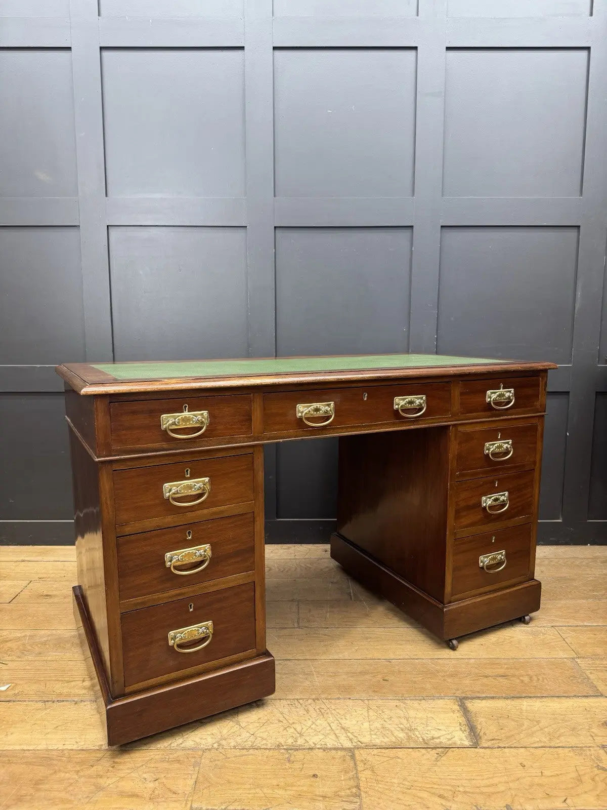 Victorian walnut writing desk brown with green leather top and brass drop handles.