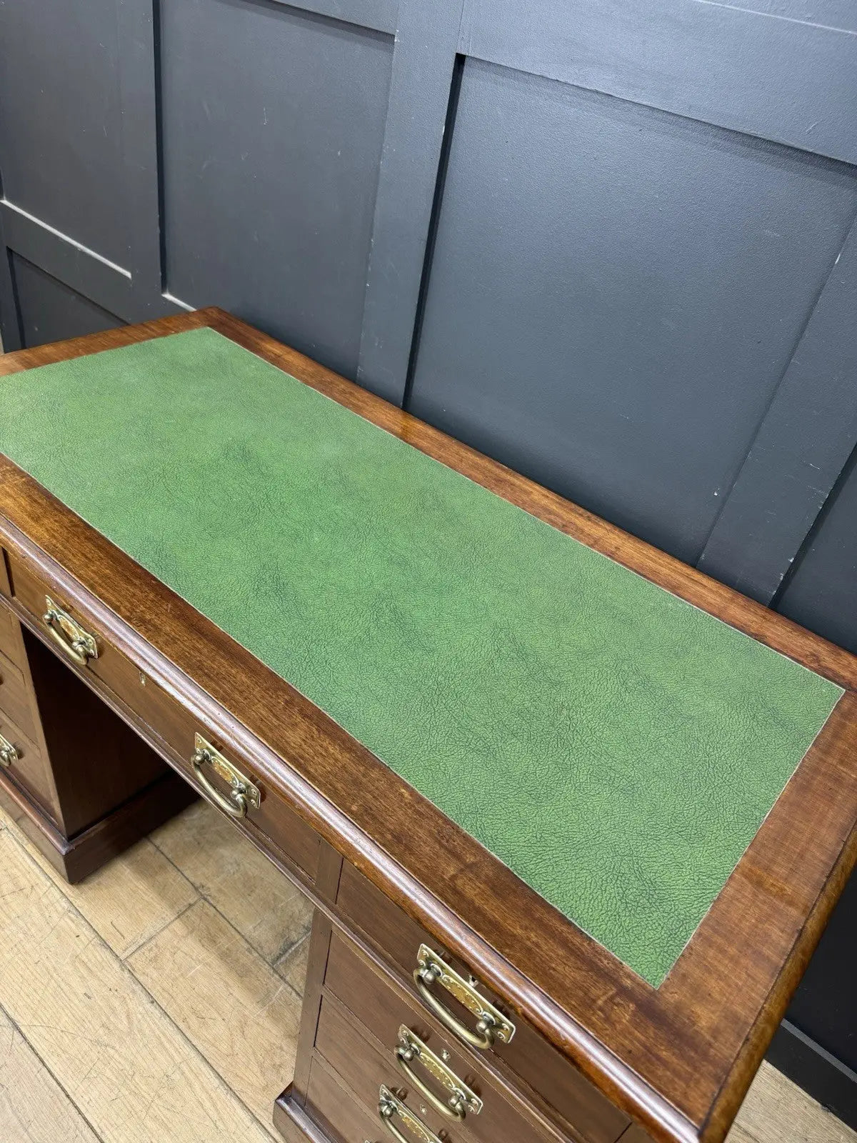 Victorian walnut writing desk brown with green leather top and brass drop handles.