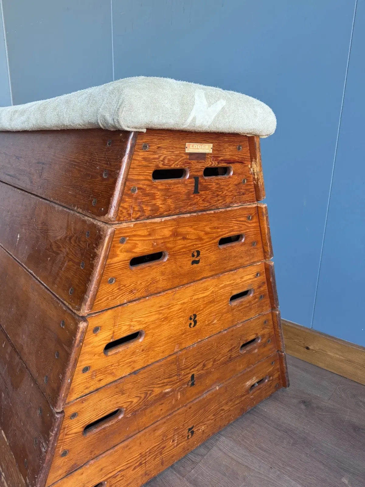 Lodge vintage wooden pommel horse with original maker's label, padded top, and worn patina.