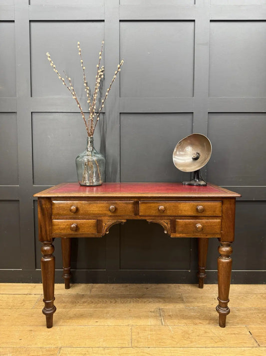 Victorian mahogany writing desk brown with red leather surface and four drawers.