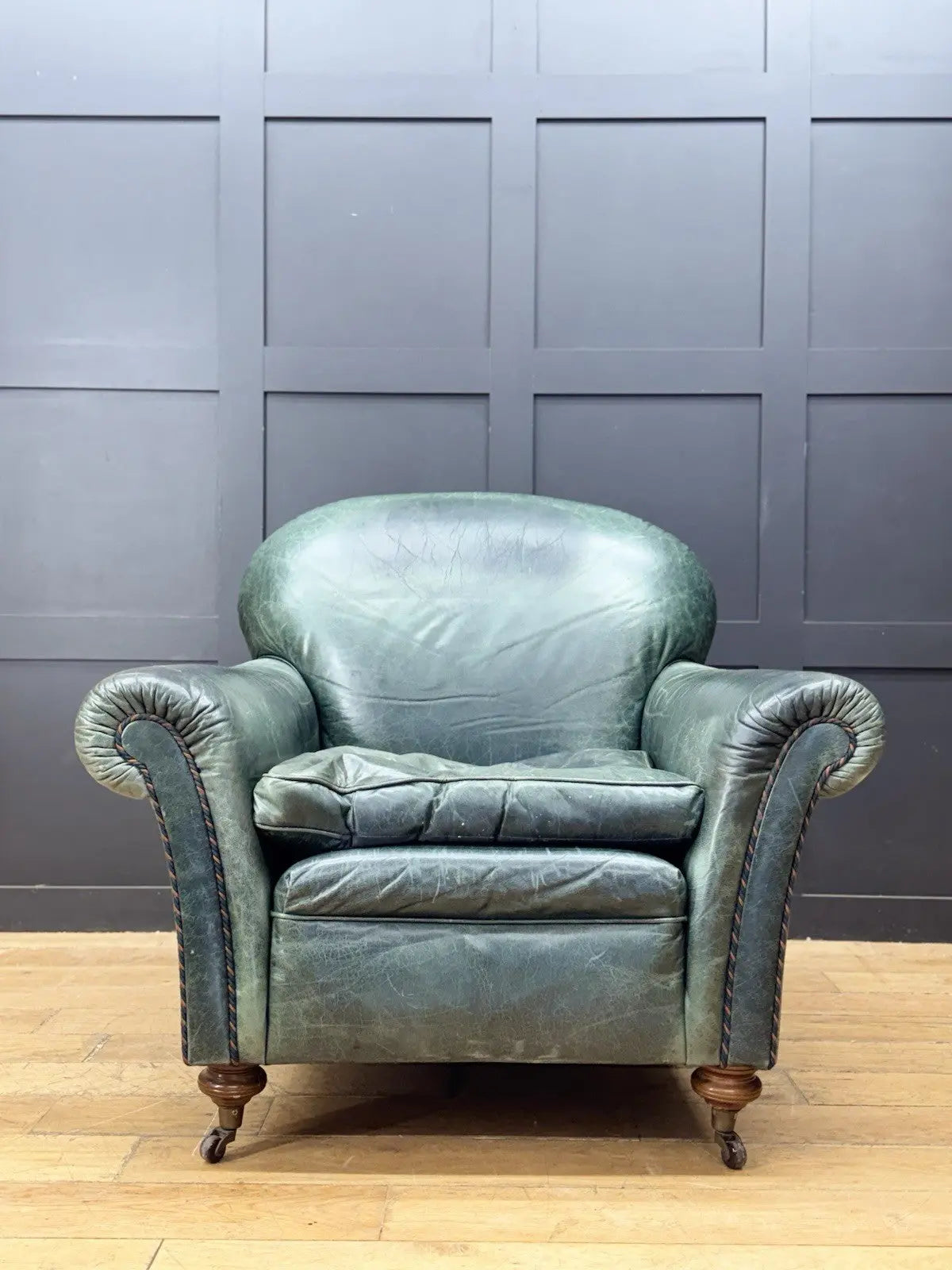 Tetrad green leather armchair with gathered detailing, twisted piping, and original manufacturer's label.