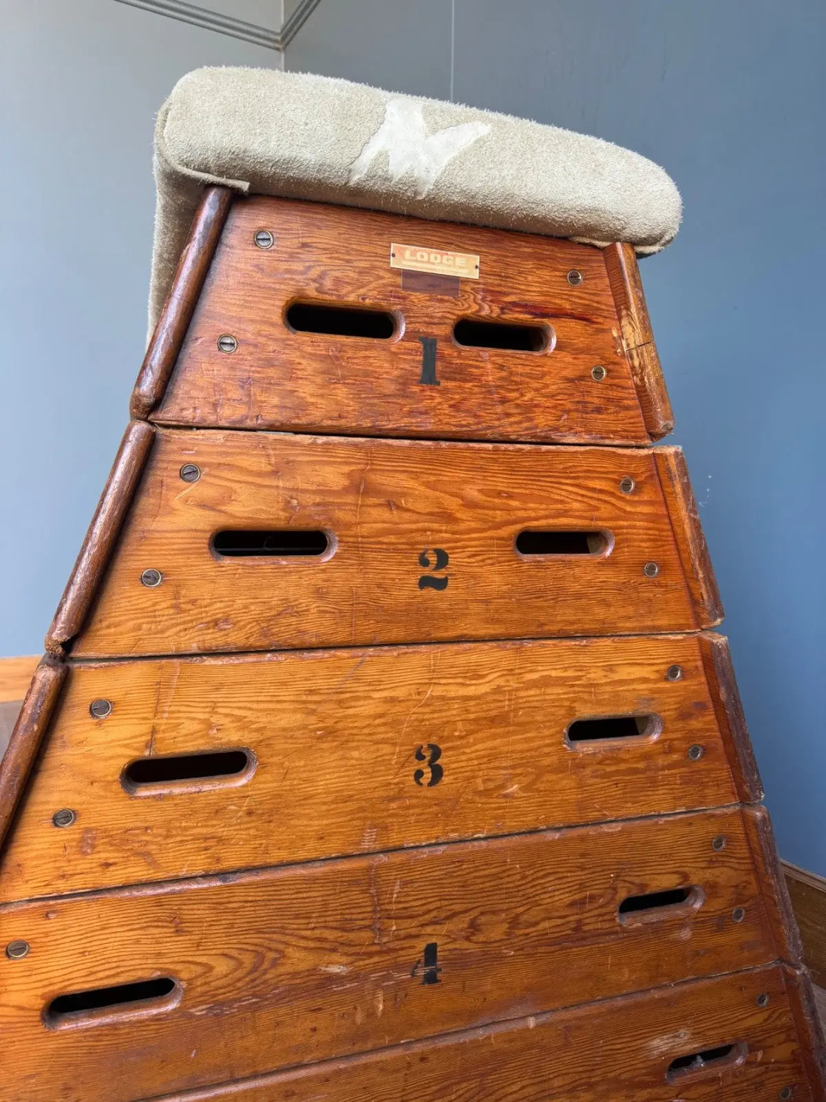 Lodge vintage wooden pommel horse with original maker's label, padded top, and worn patina.