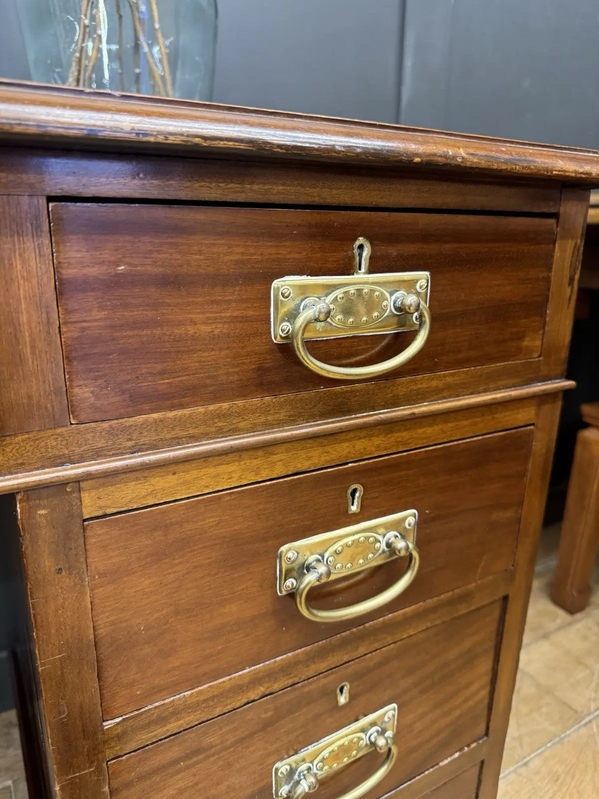 Victorian walnut writing desk brown with green leather top and brass drop handles.