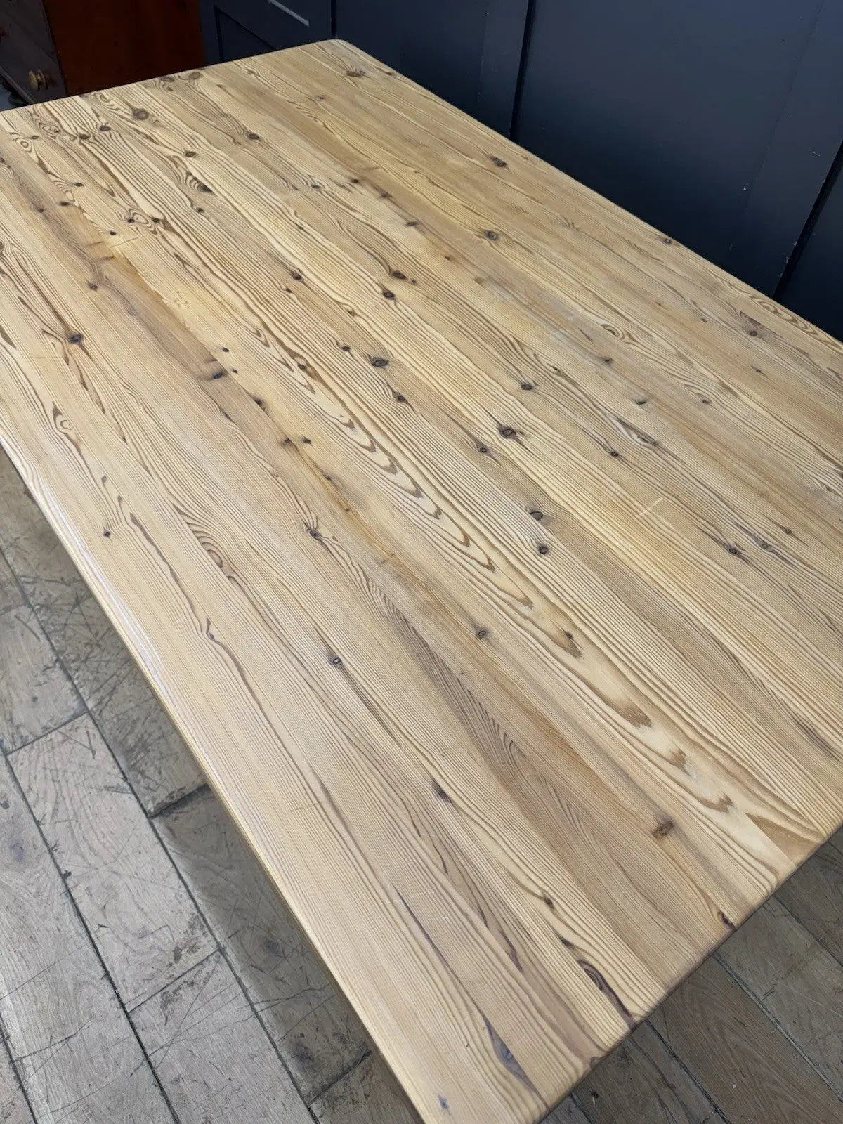 Vintage brown farmhouse dining table with turned legs and central drawer featuring white ceramic knob.
