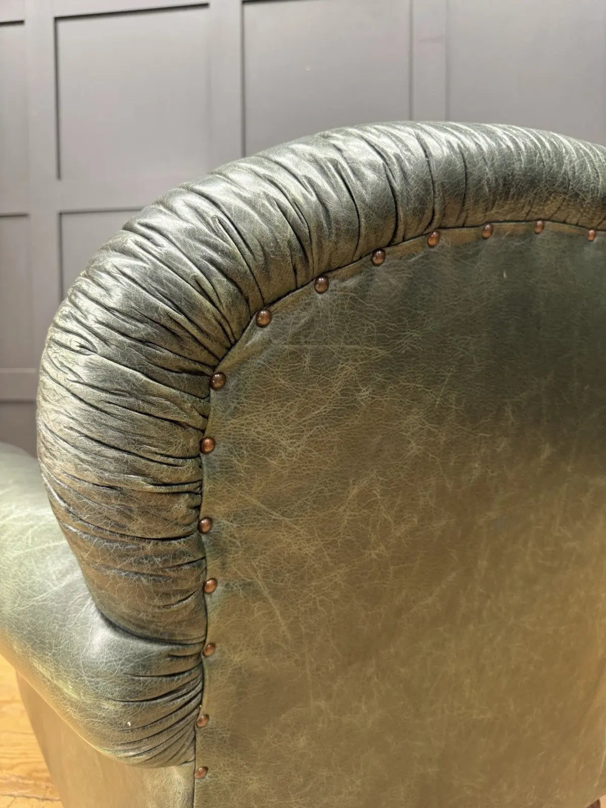 Tetrad green leather armchair with gathered detailing, twisted piping, and original manufacturer's label.