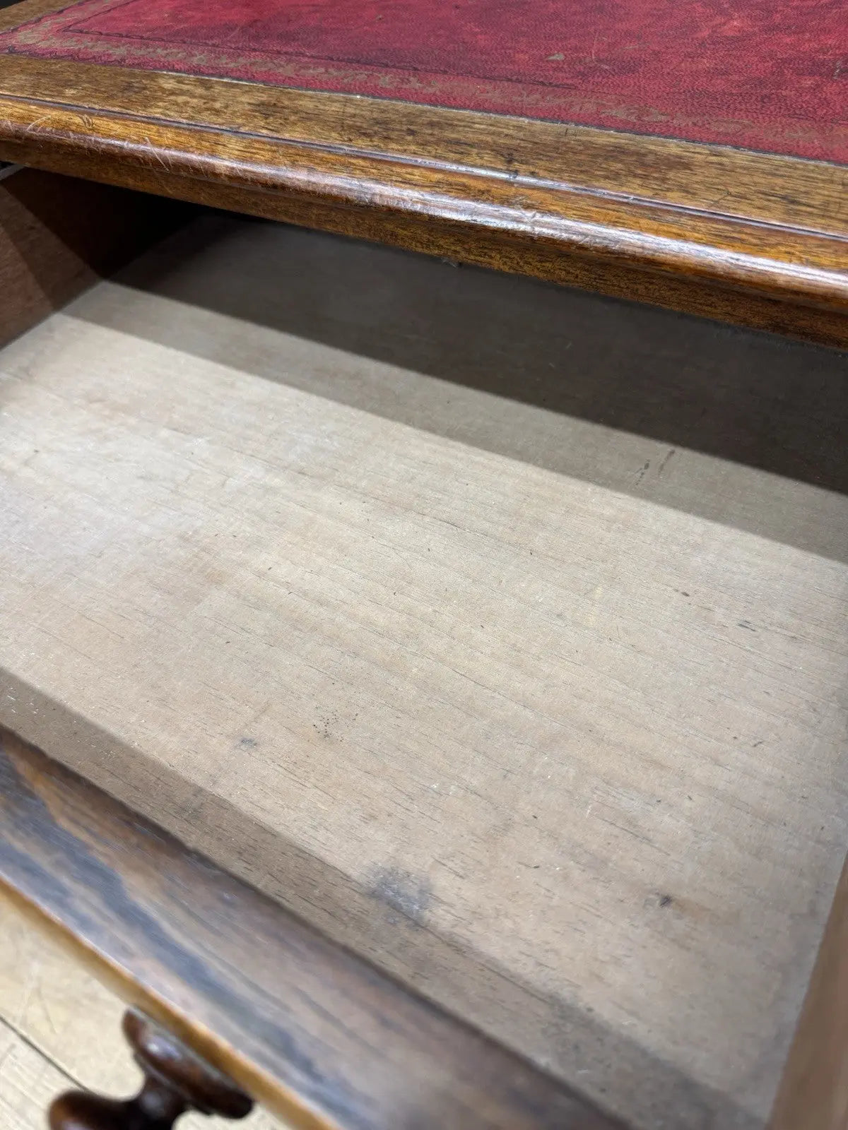Victorian mahogany writing desk brown with red leather surface and four drawers.