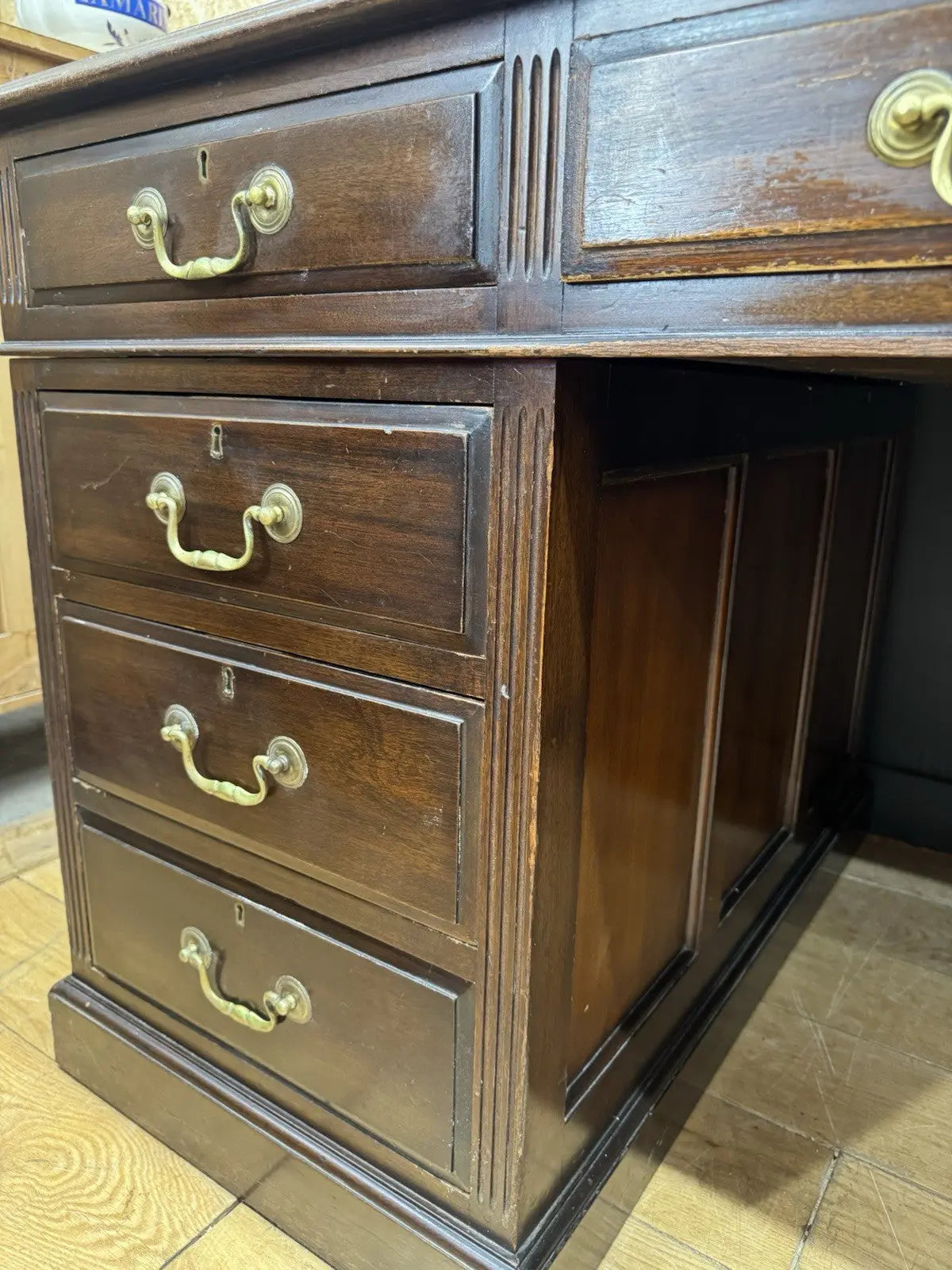 Twin antique mahogany writing desk with red leather top and brass swan-neck handles.