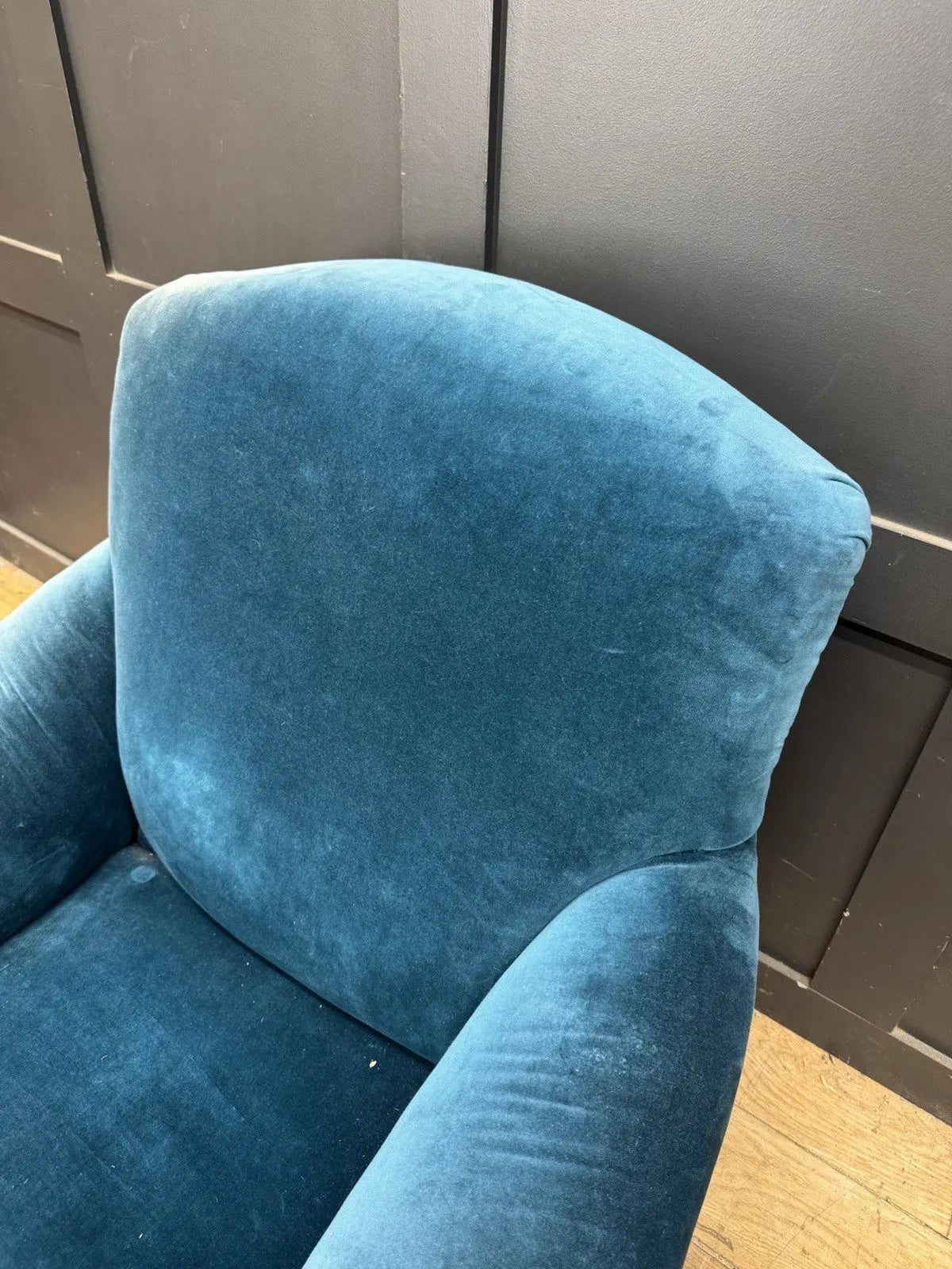 Antique blue velvet armchair with curved back, scroll arms, and stamped 'P' on frame.