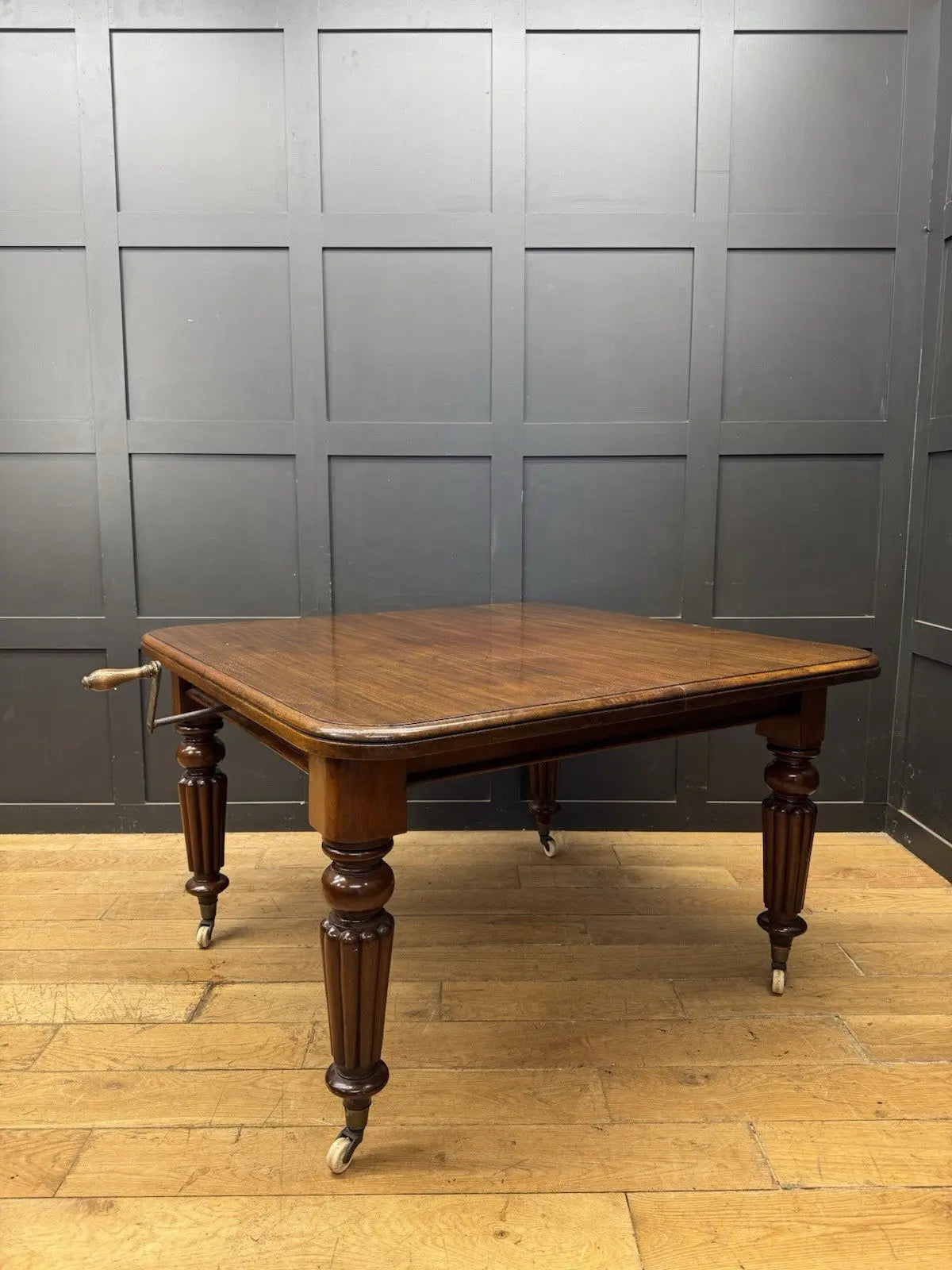Victorian mahogany dining table brown fluted legs with brass castors and wind-out mechanism.