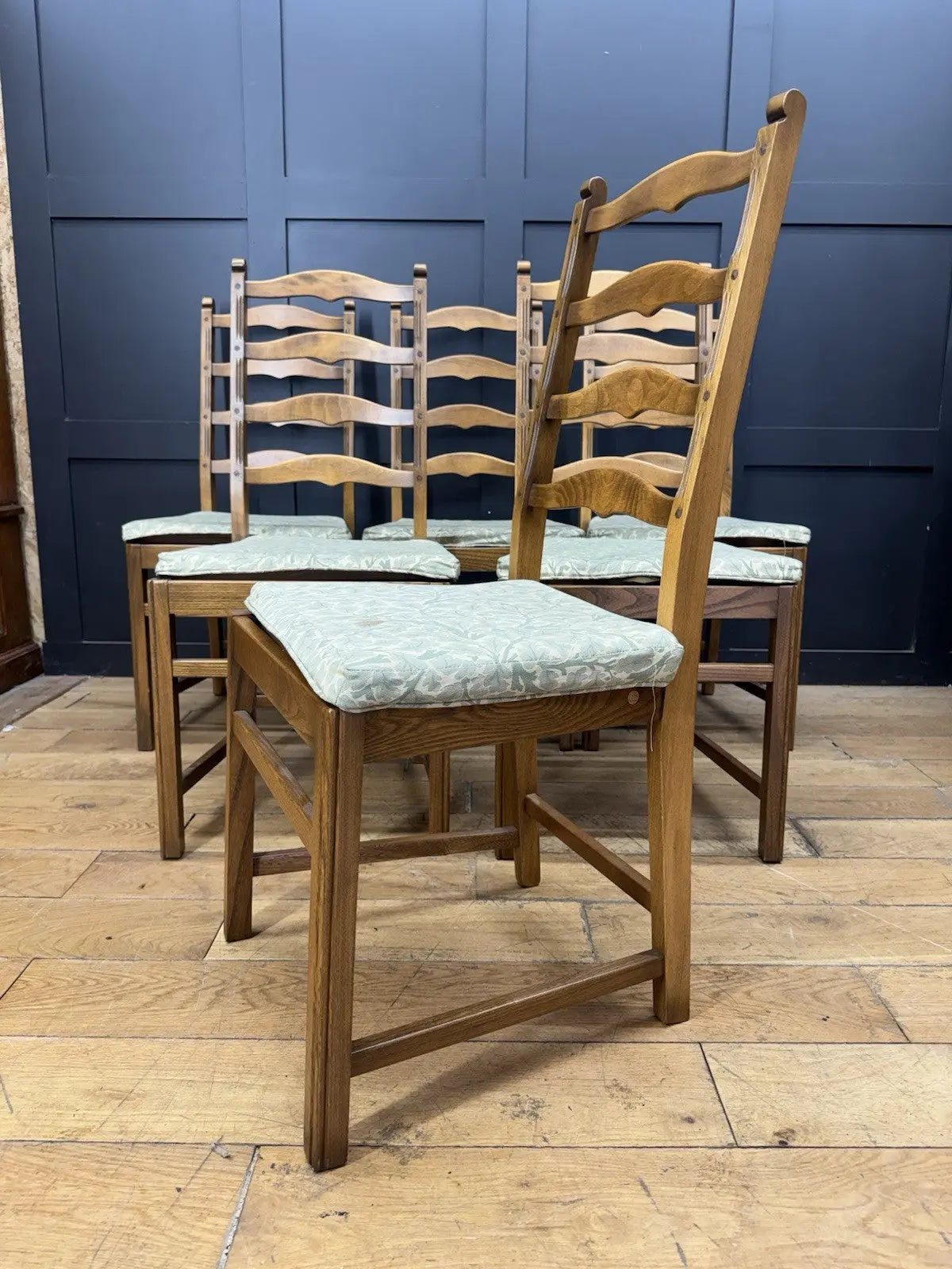 Ercol vintage ladderback dining chairs brown elm beech with green botanical patterned seat pads.
