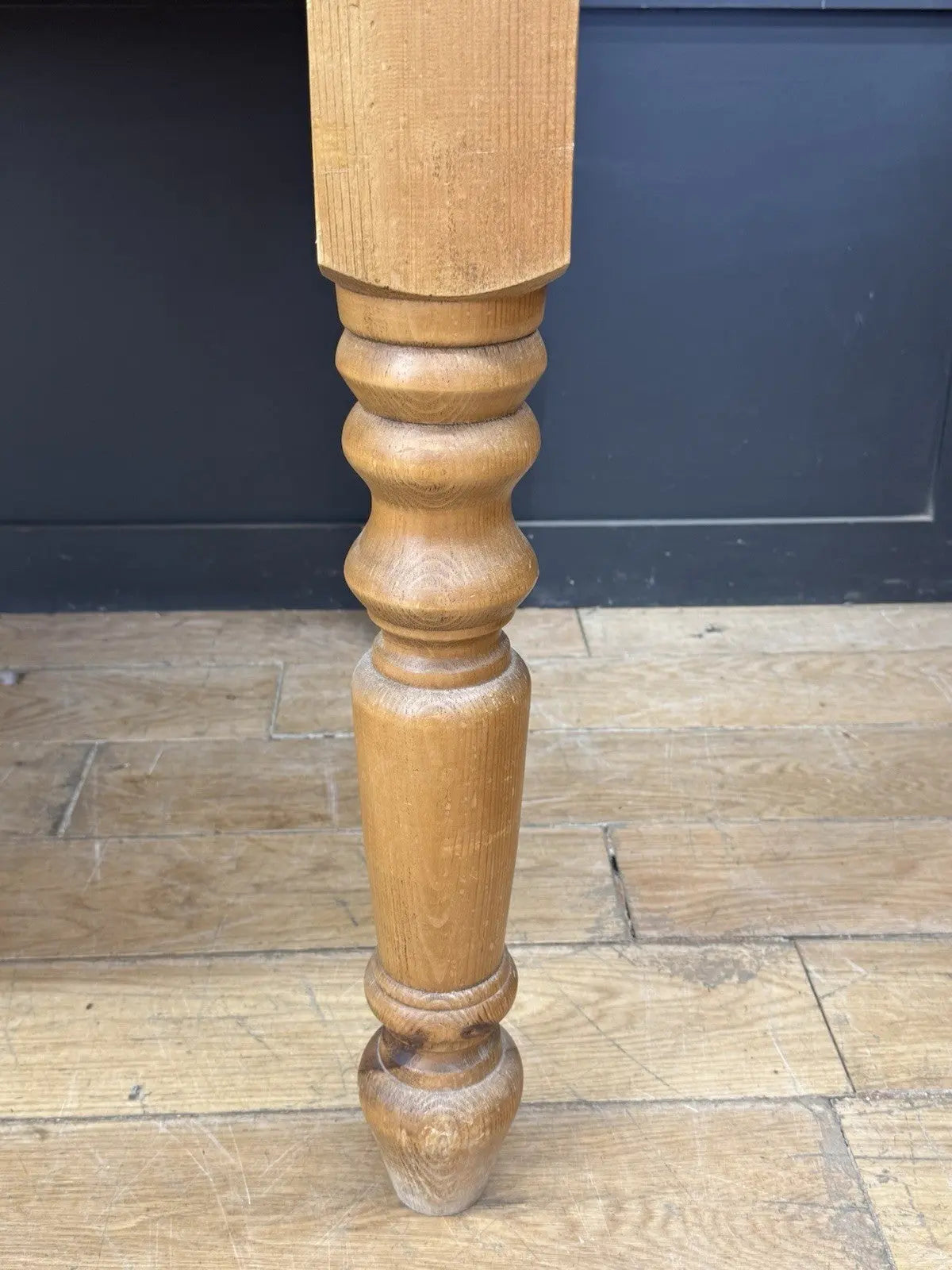 Pine farmhouse dining table brown rectangular top with turned legs and natural grain.