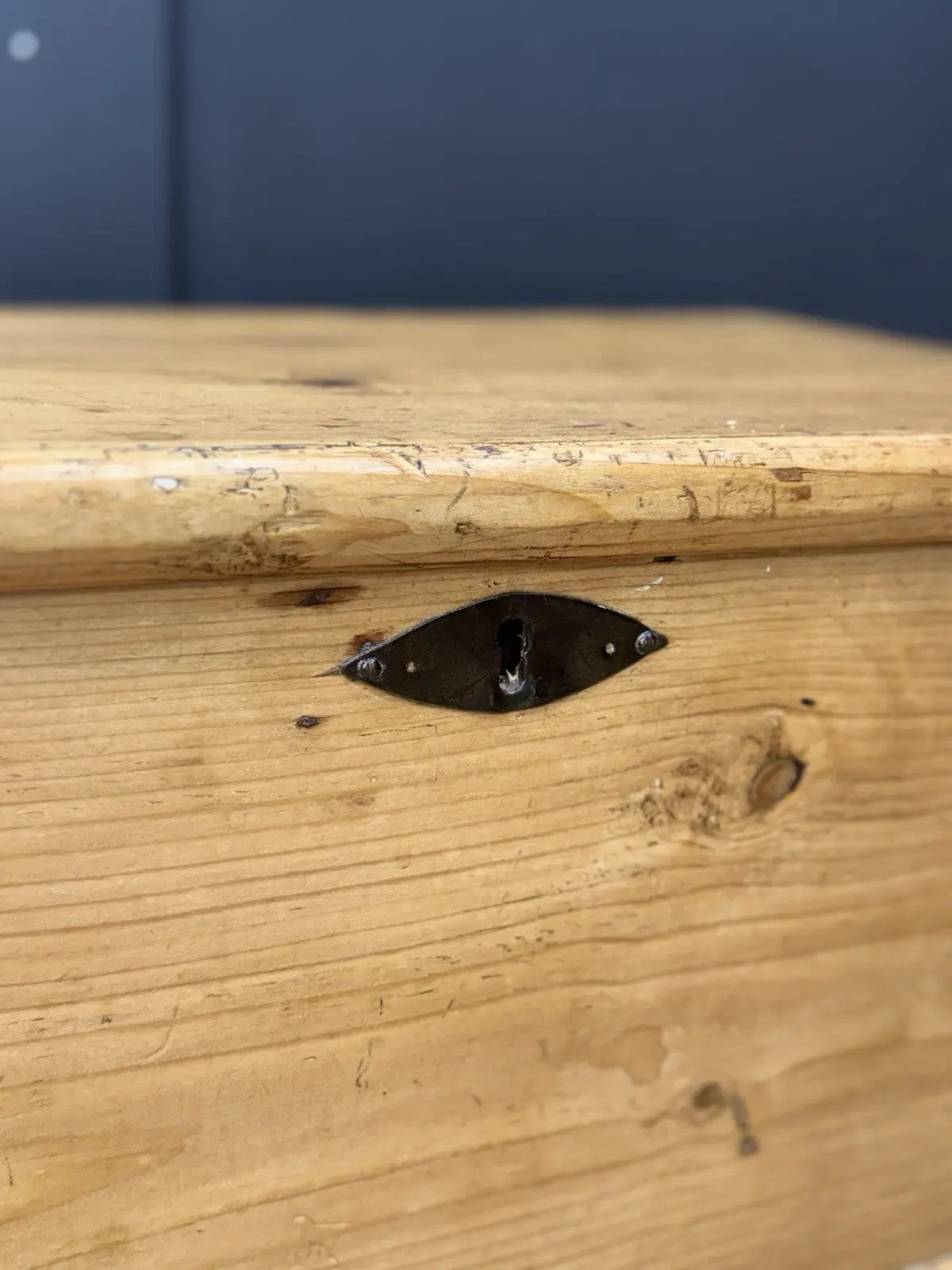 Vintage pine coffee table brown with natural grain and dark metal corner brackets.