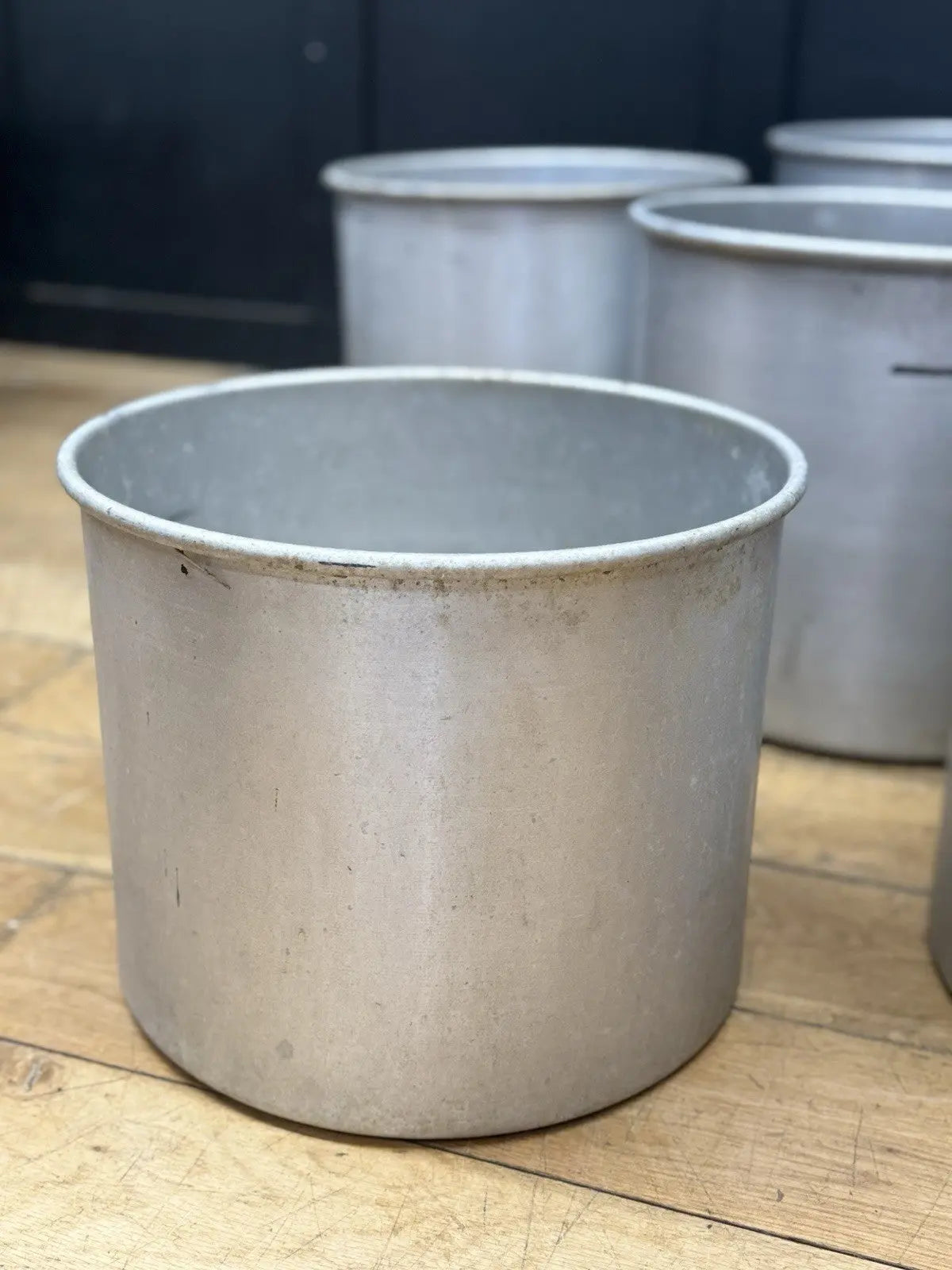Parisotto green aluminium planters set of seven with cylindrical bodies and maker's label.