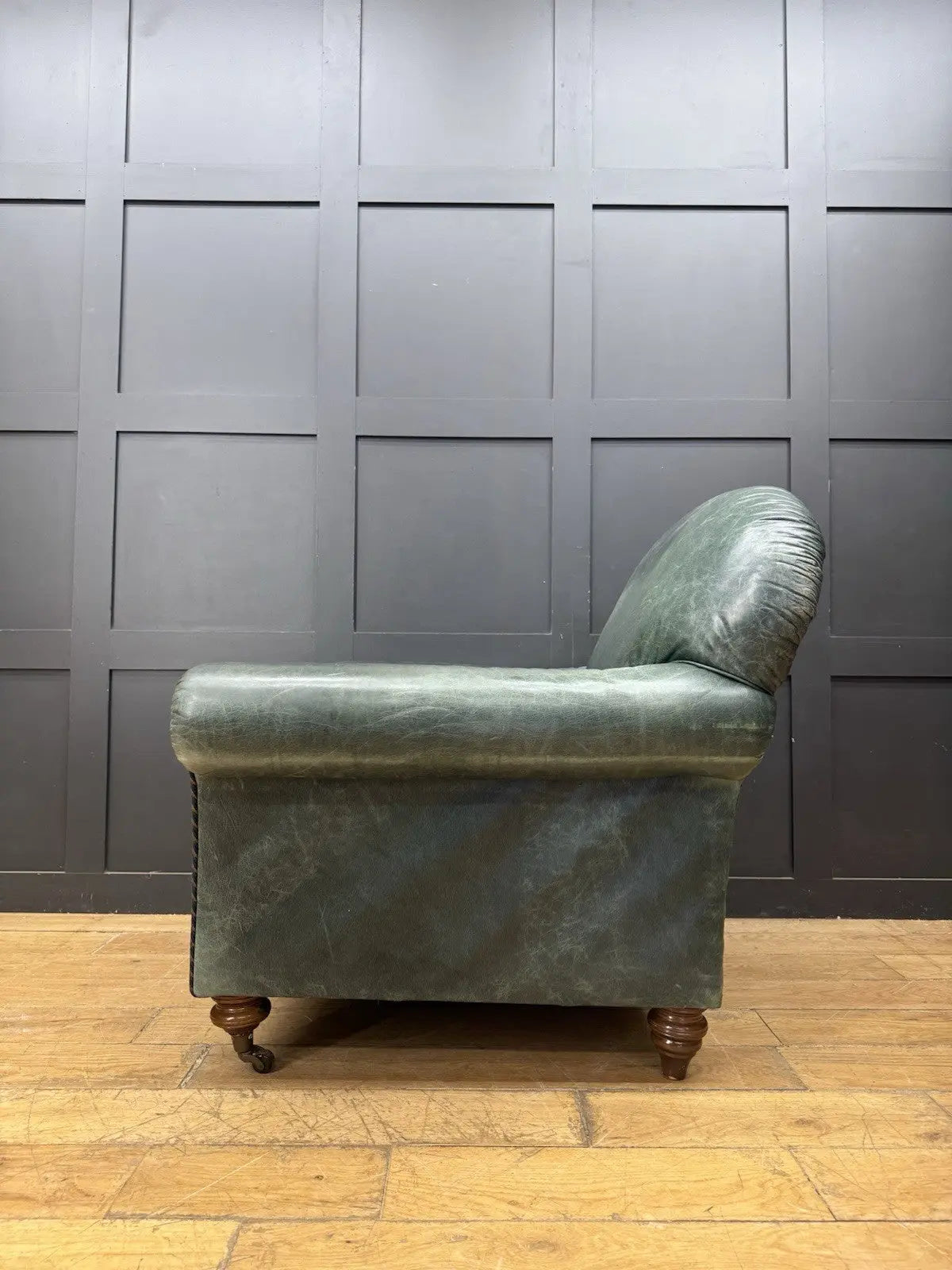 Tetrad green leather armchair with gathered detailing, twisted piping, and original manufacturer's label.