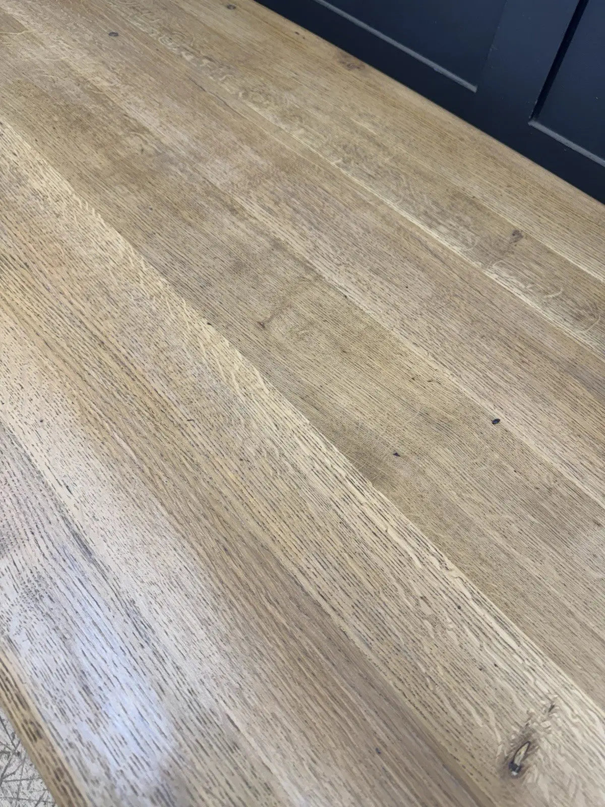 Ercol brown oak refectory dining table with natural wood grain and traditional trestle base.
