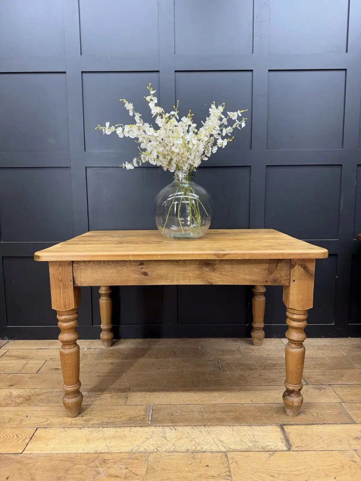 Pine farmhouse dining table brown rectangular top with turned legs and natural grain.