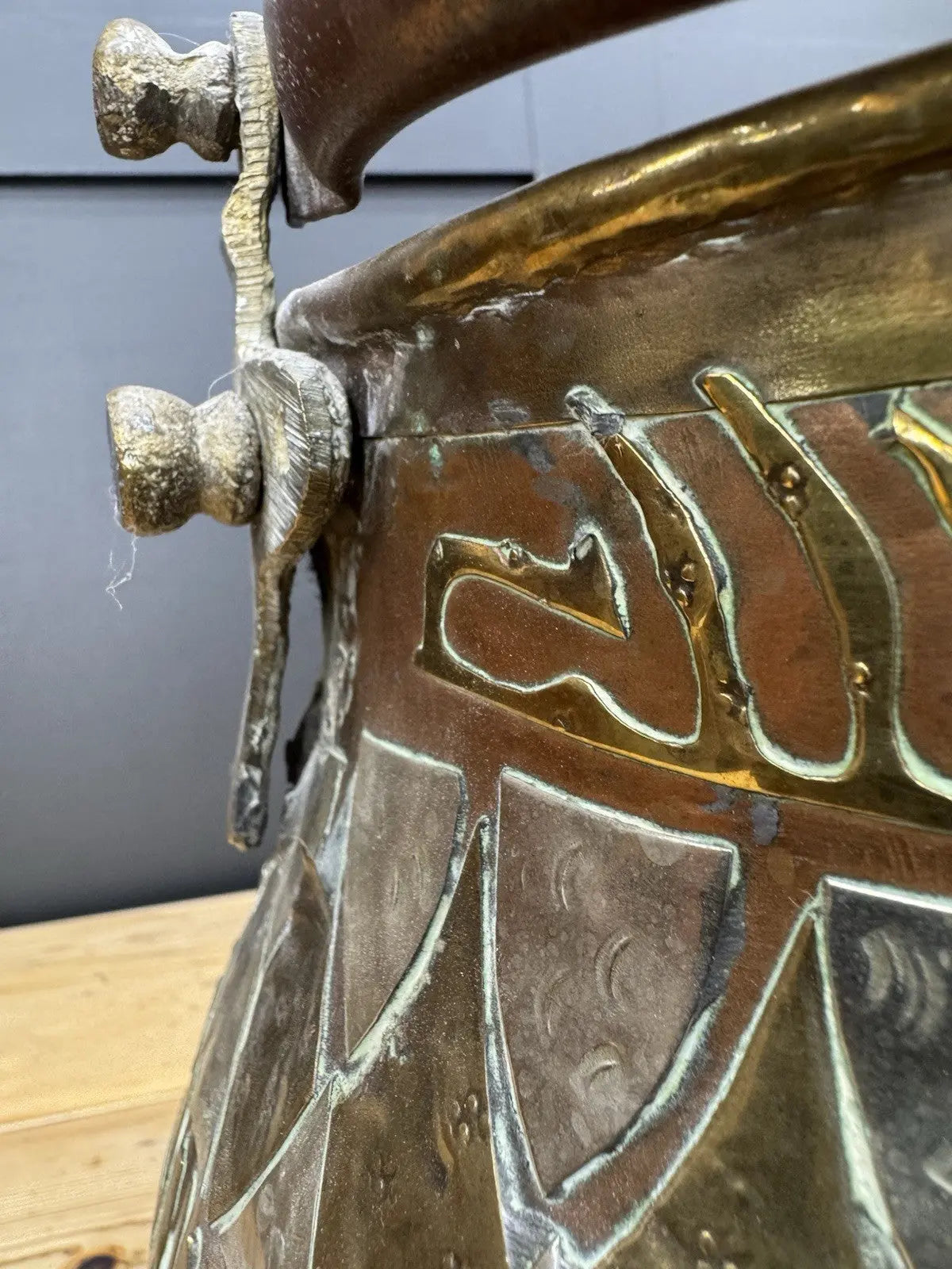 Antique Moroccan copper tea kettle and brass cauldron planter with ornate geometric patterns.