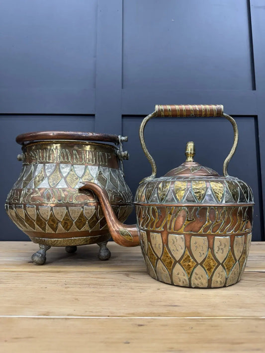 Antique Moroccan copper tea kettle and brass cauldron planter with ornate geometric patterns.