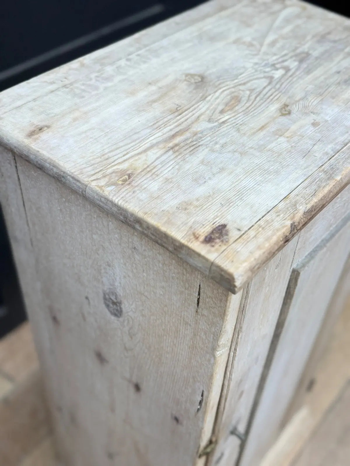 Antique beige pine cupboard with stripped finish, brass knob, and painted interior.