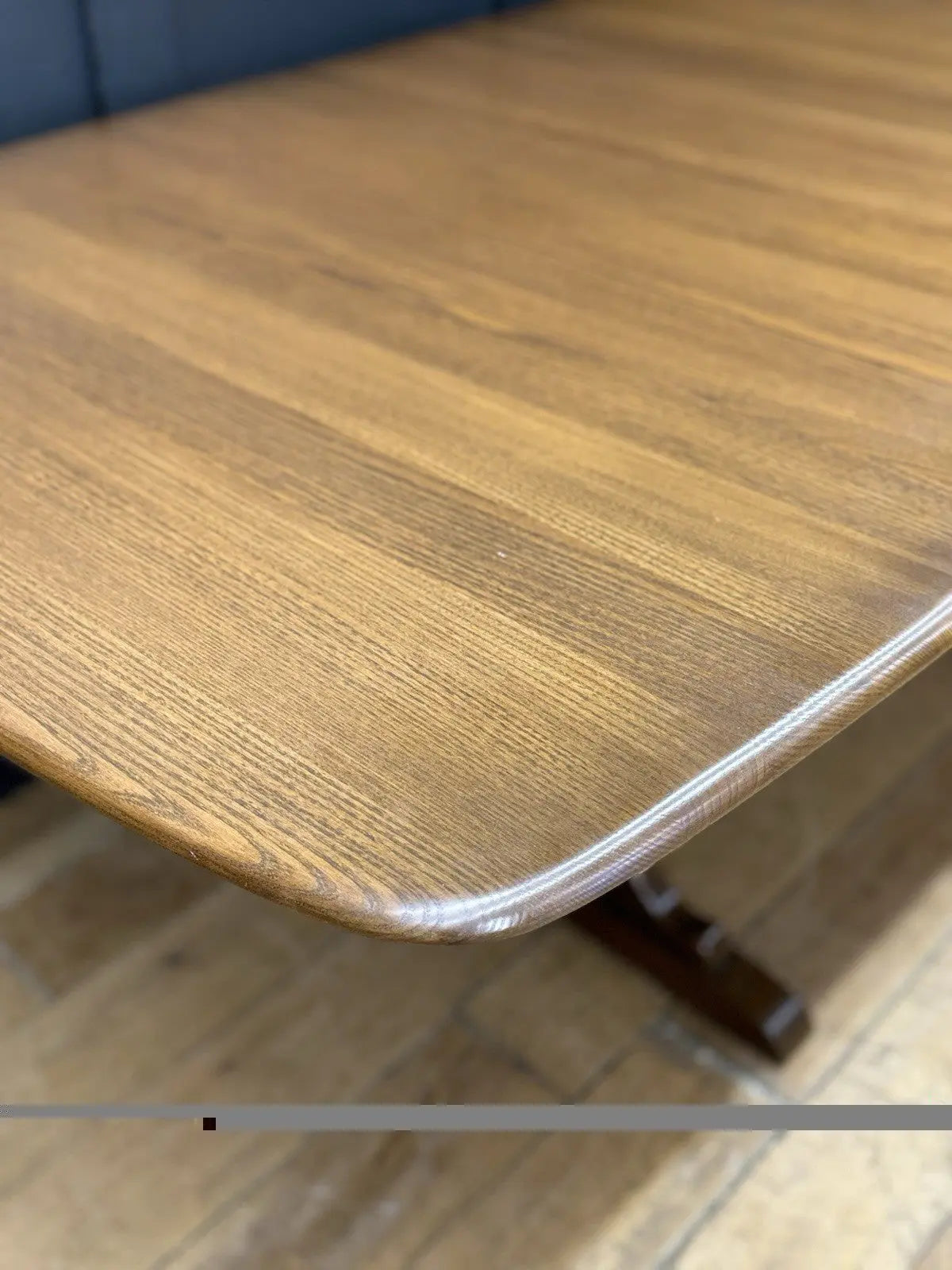 Ercol brown extending dining table with solid elm top and three individual extension leaves.