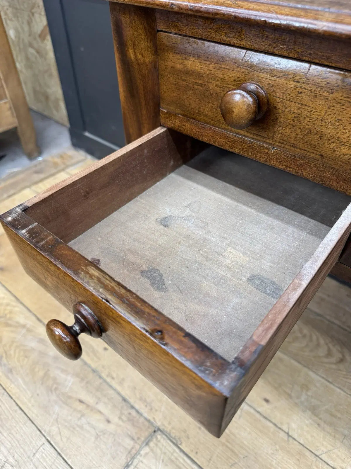 Victorian mahogany writing desk brown with red leather surface and four drawers.