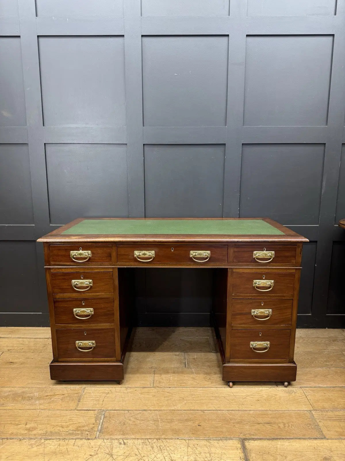 Victorian walnut writing desk brown with green leather top and brass drop handles.