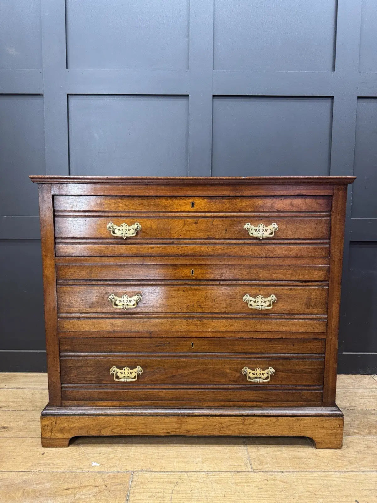 Edwardian brown dresser with three long drawers, decorative brass handles and attractive wood figuring.