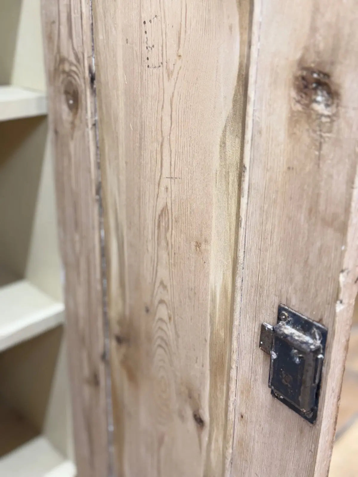 Antique beige pine cupboard with stripped finish, brass knob, and painted interior.