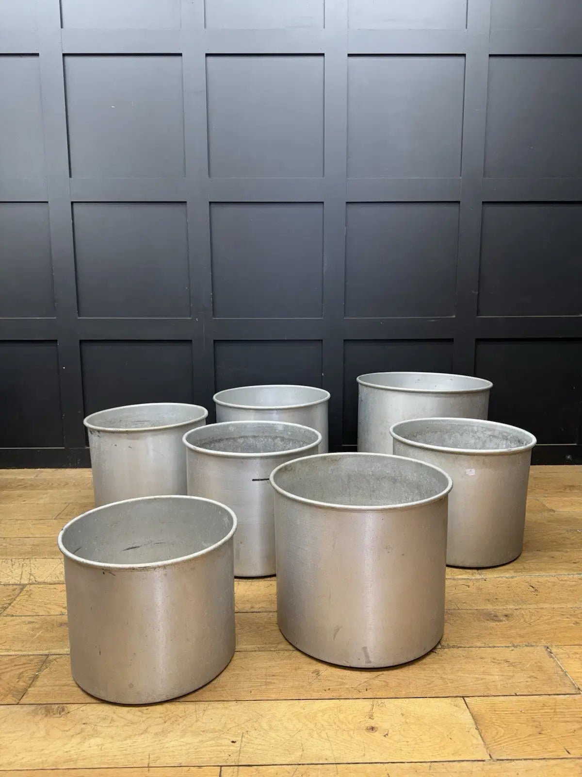 Parisotto green aluminium planters set of seven with cylindrical bodies and maker's label.