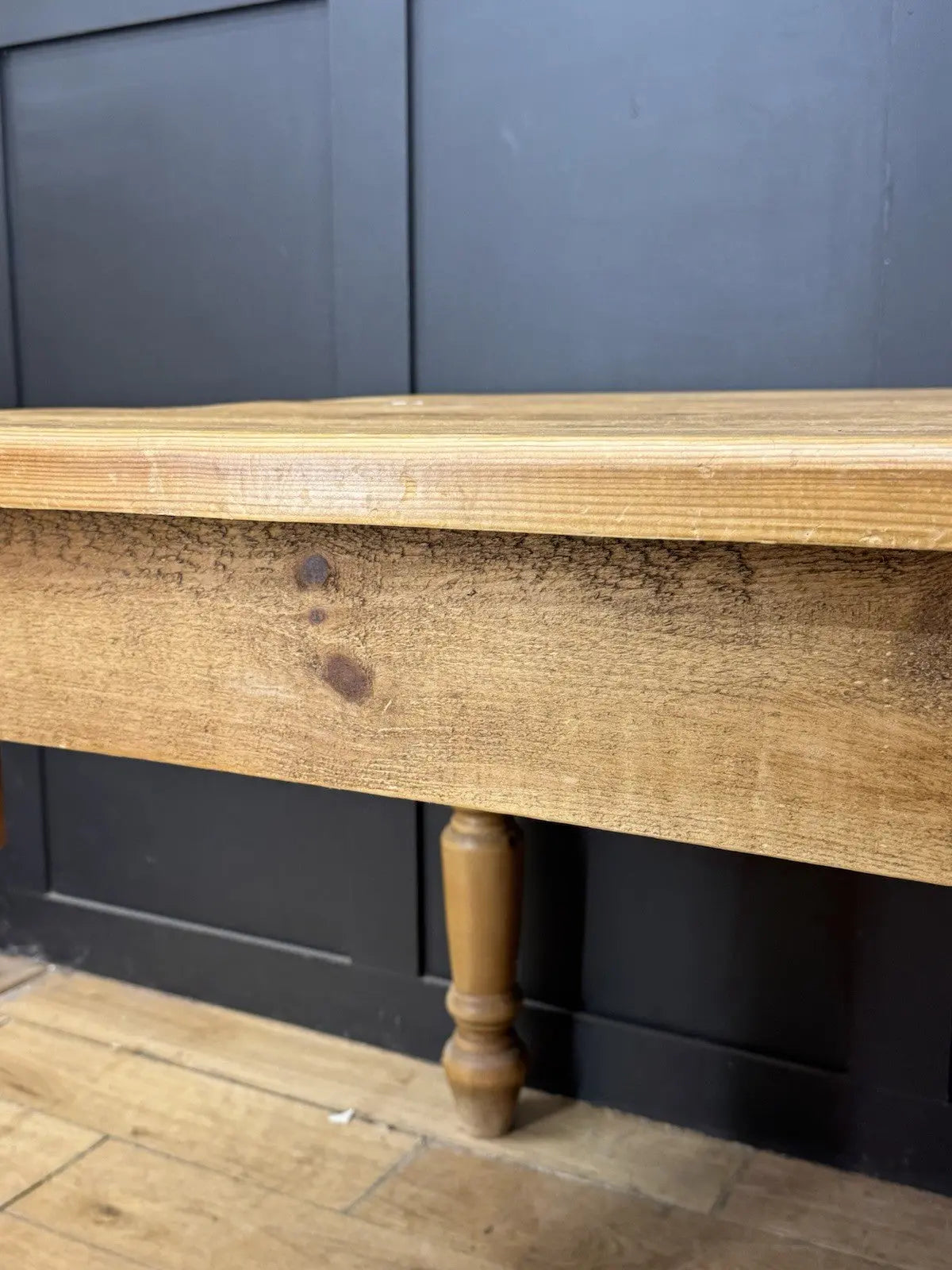 Pine farmhouse dining table brown rectangular top with turned legs and natural grain.