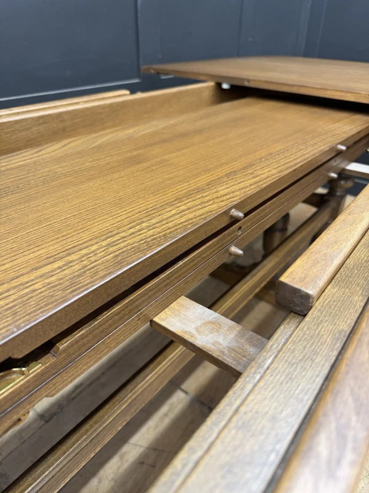 Ercol brown extending dining table with solid elm top and three individual extension leaves.