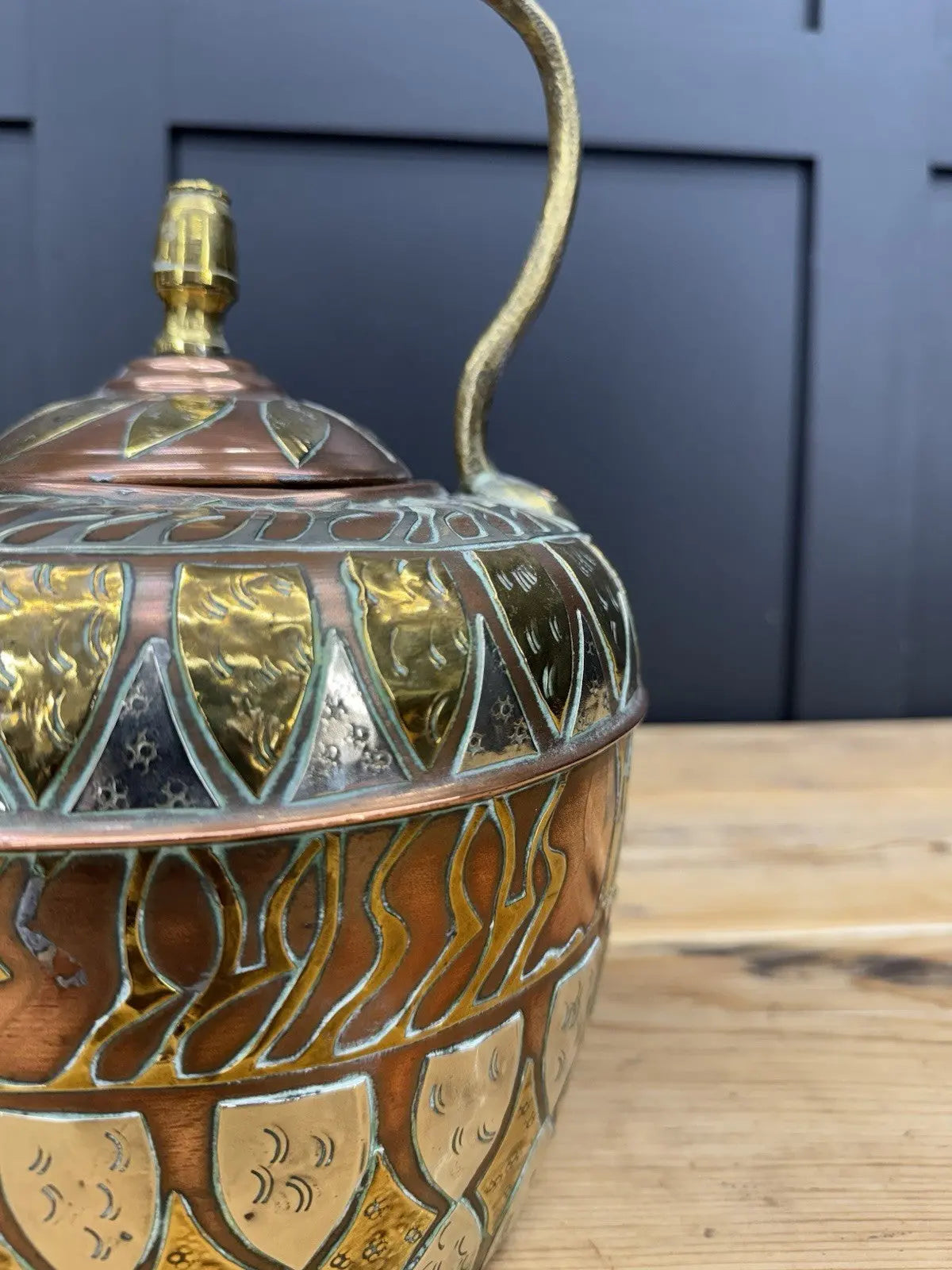 Antique Moroccan copper tea kettle and brass cauldron planter with ornate geometric patterns.